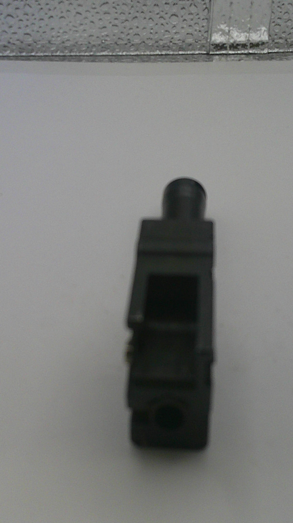 Black plastic component on a white background