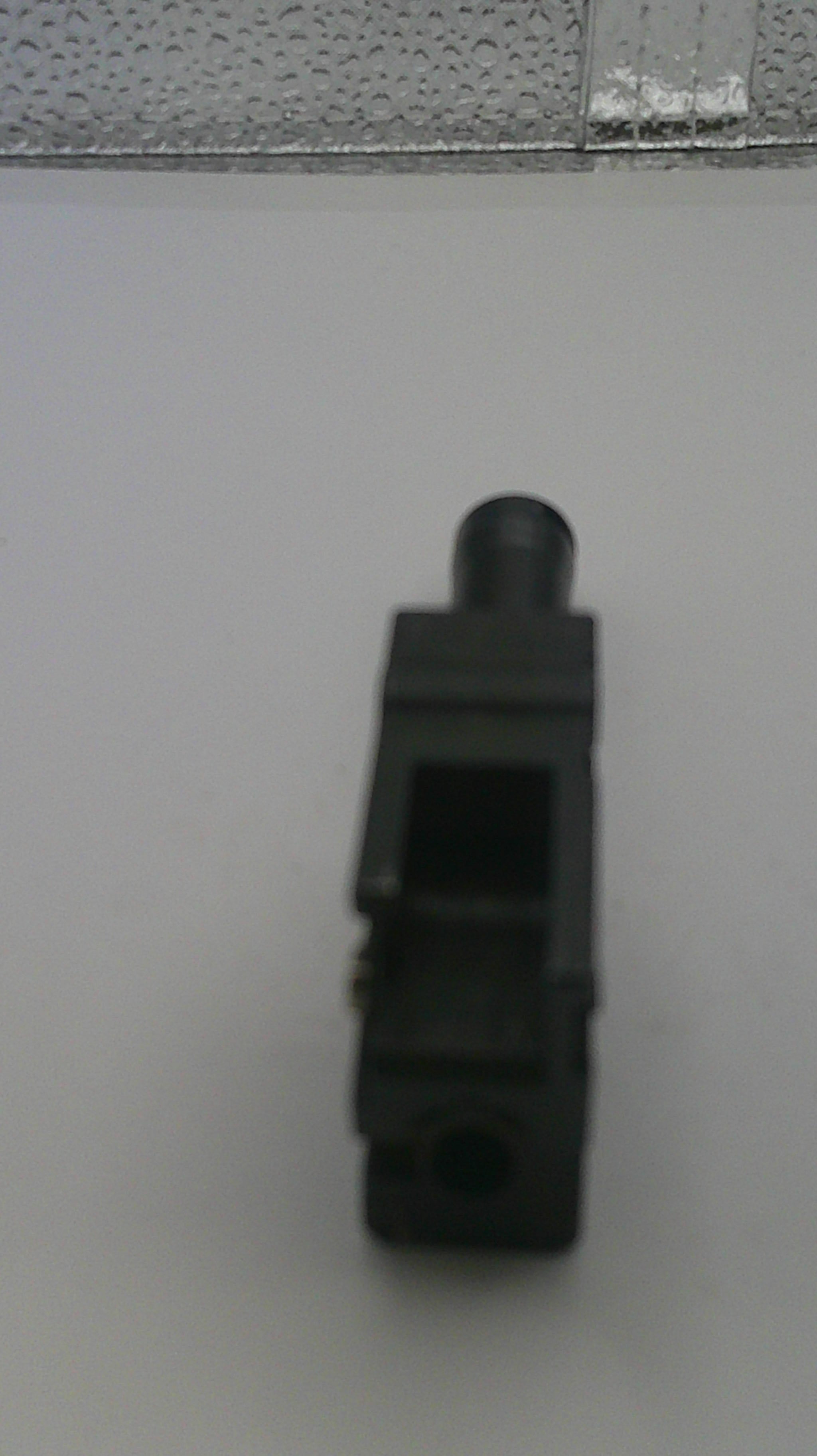 Black plastic component on a white background