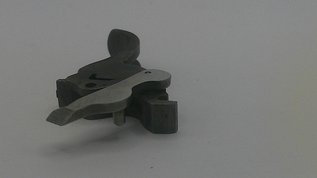 Metallic gun trigger on a gray background