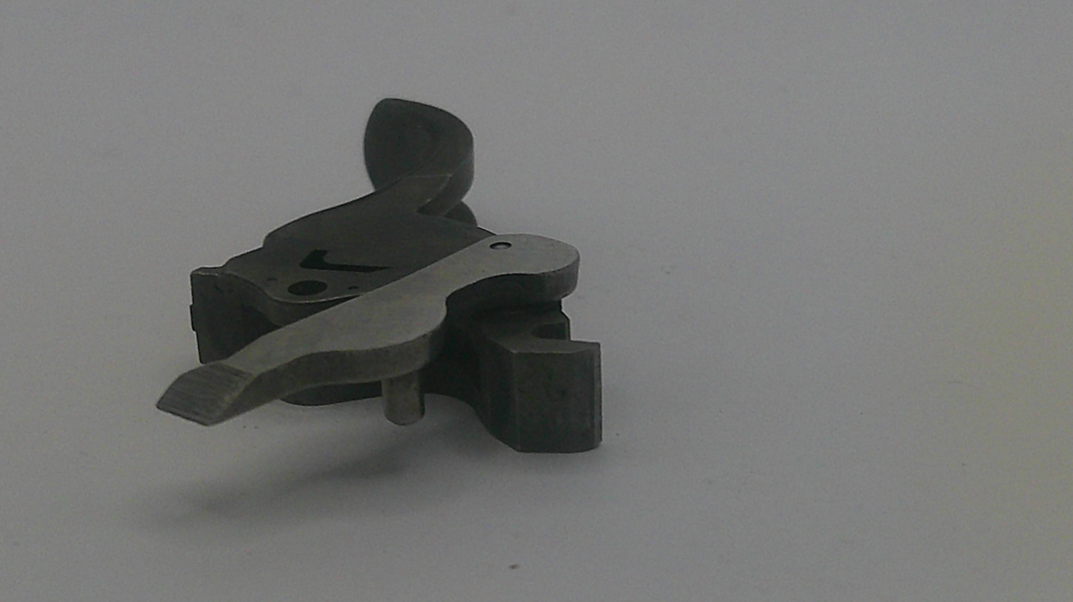 Metallic gun trigger on a gray background