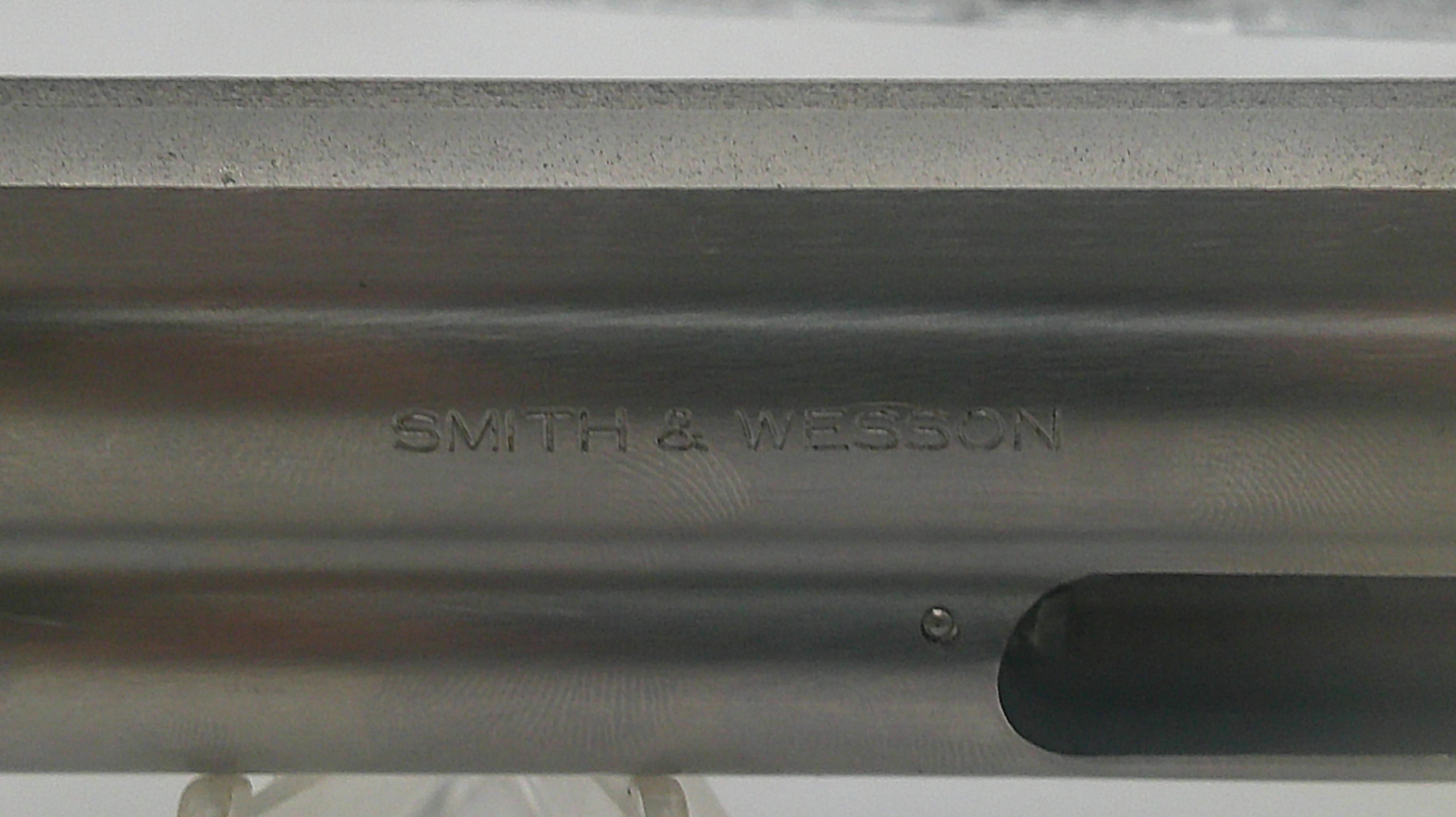 Close-up of a metallic object with 'Smith & Wesson' engraving.