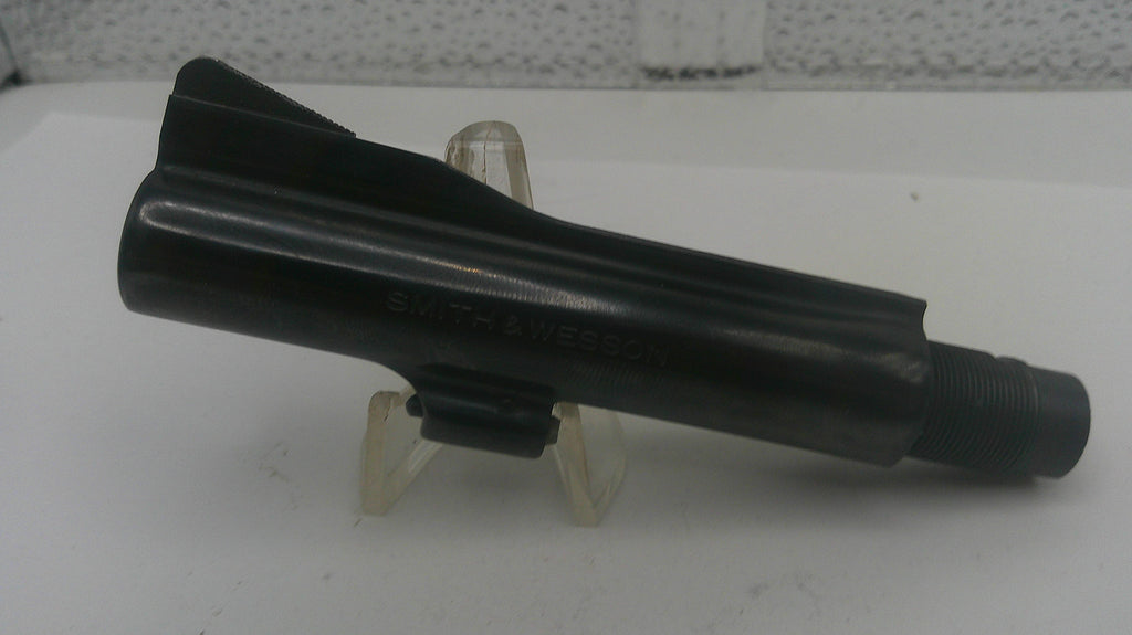 Black metal component on a white stand with a blurred background