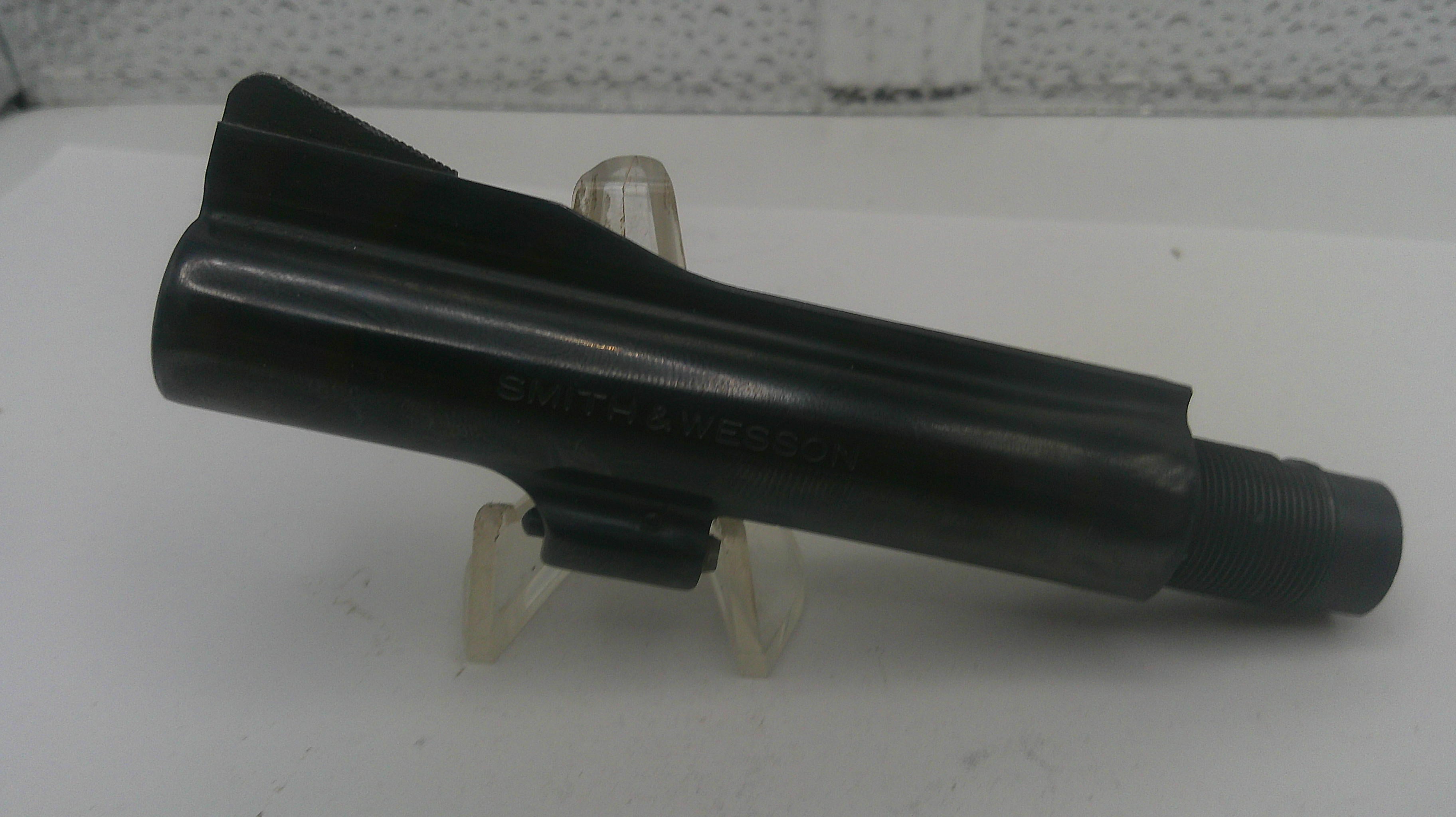 Black metal component on a white stand with a blurred background