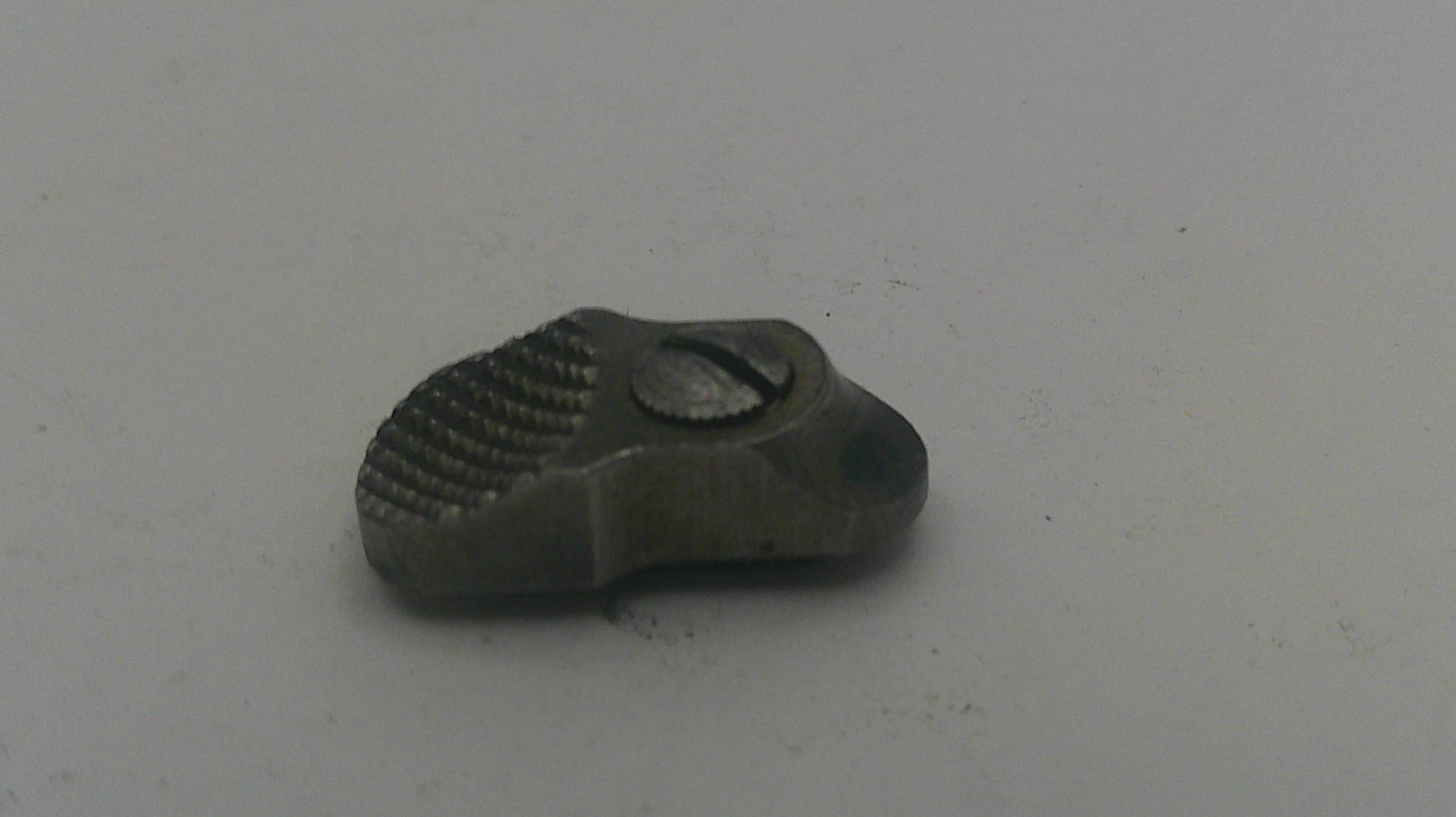 Small metallic object on a light gray background