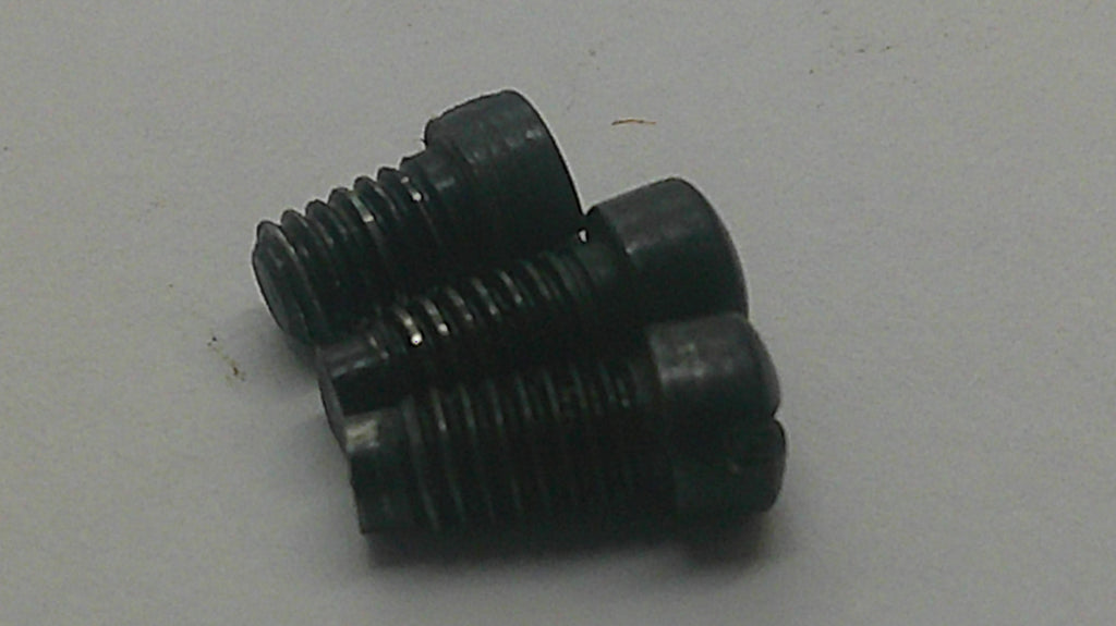 Three black metal threaded screws with countersunk heads, arranged on a plain light gray surface.