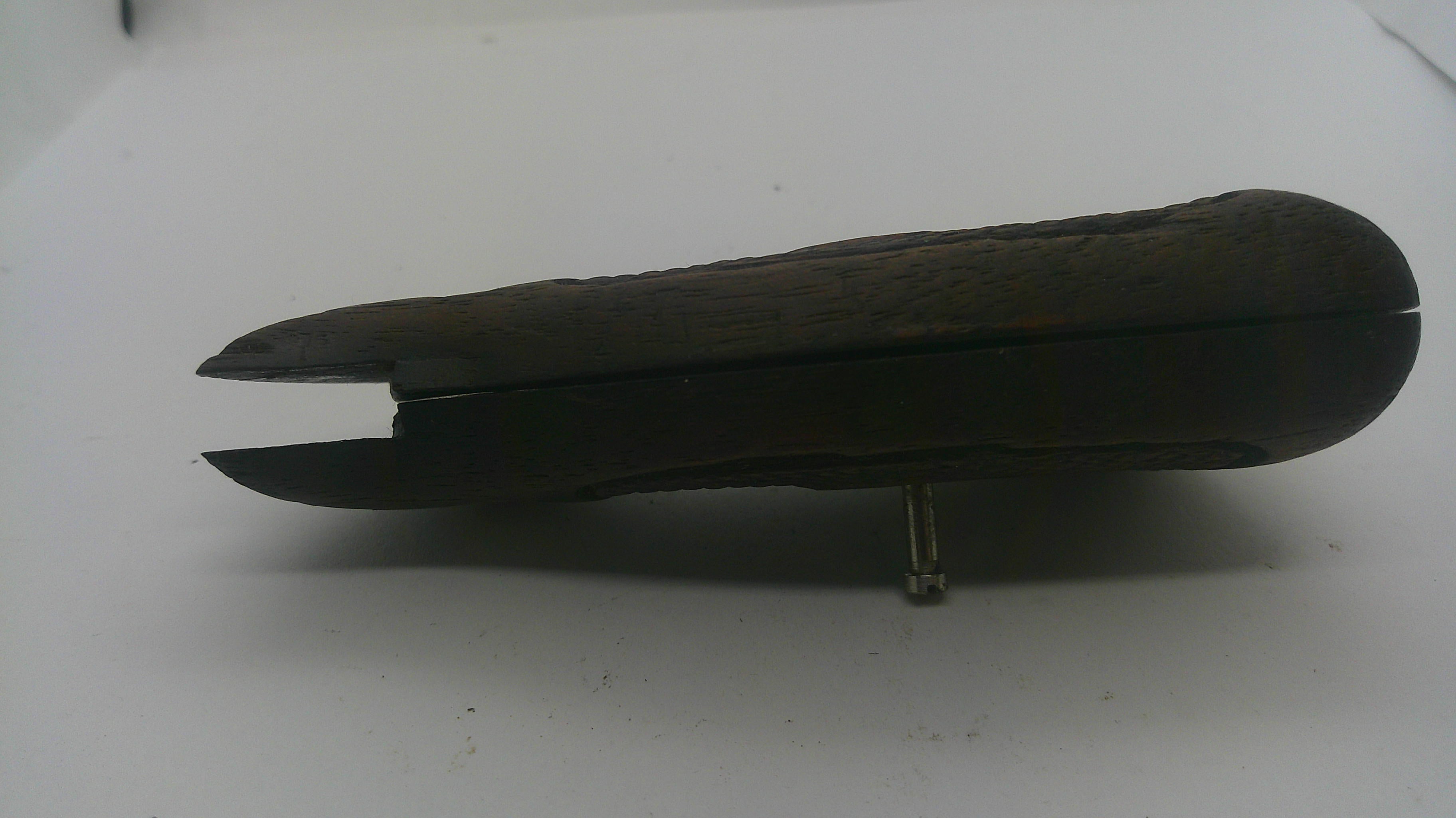 A dark brown wooden box with a carved textured lid, shown open on a plain white surface.