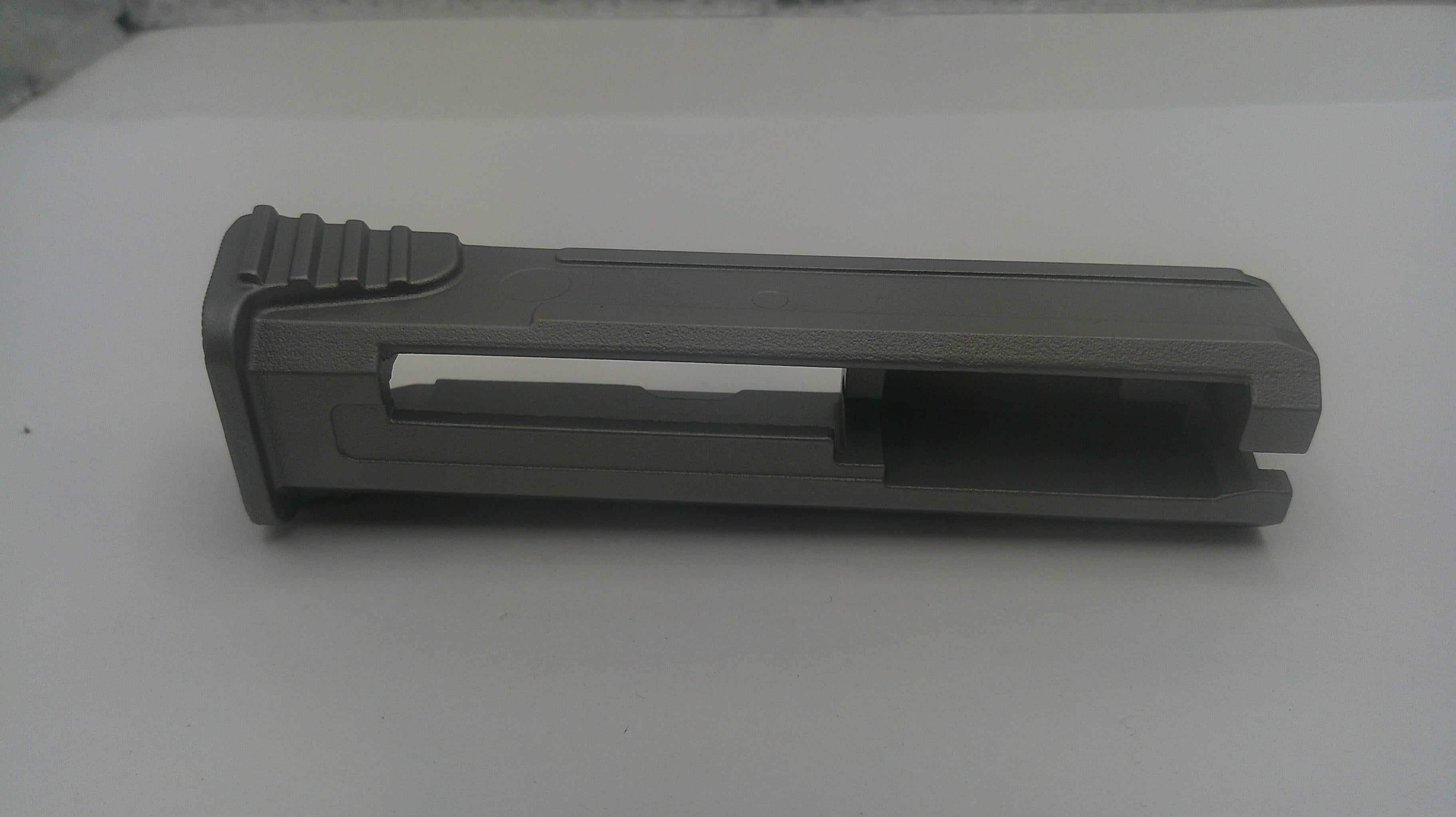 A dark gray plastic replacement part, likely a grip or handle component, shown on a plain white surface.