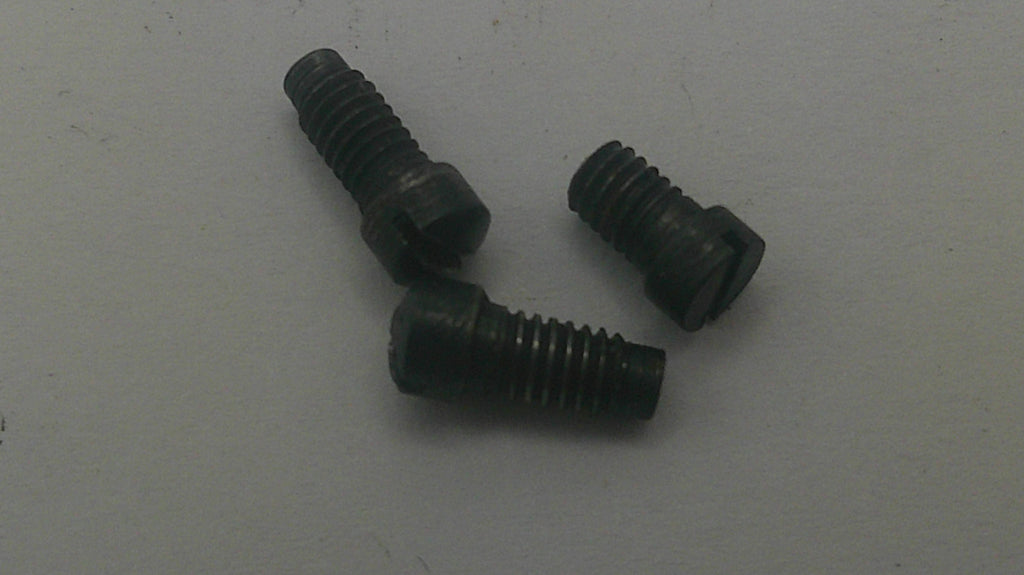 Three small black metal screws with slotted heads, arranged on a plain light gray surface.