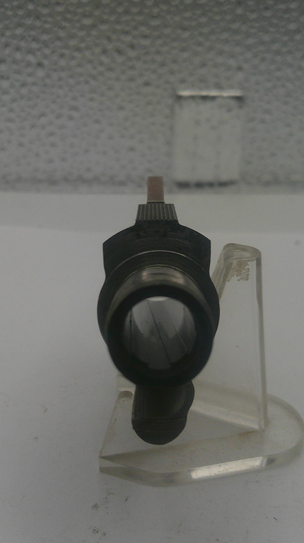 Mechanical component on a stand with a textured background