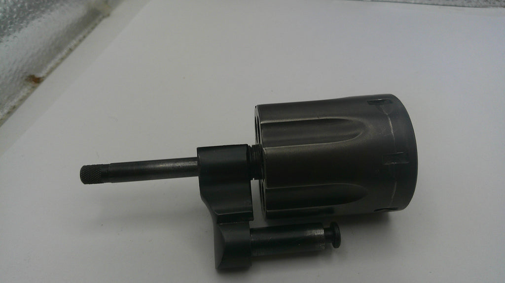 Black cylindrical object with a long nozzle on a white surface
