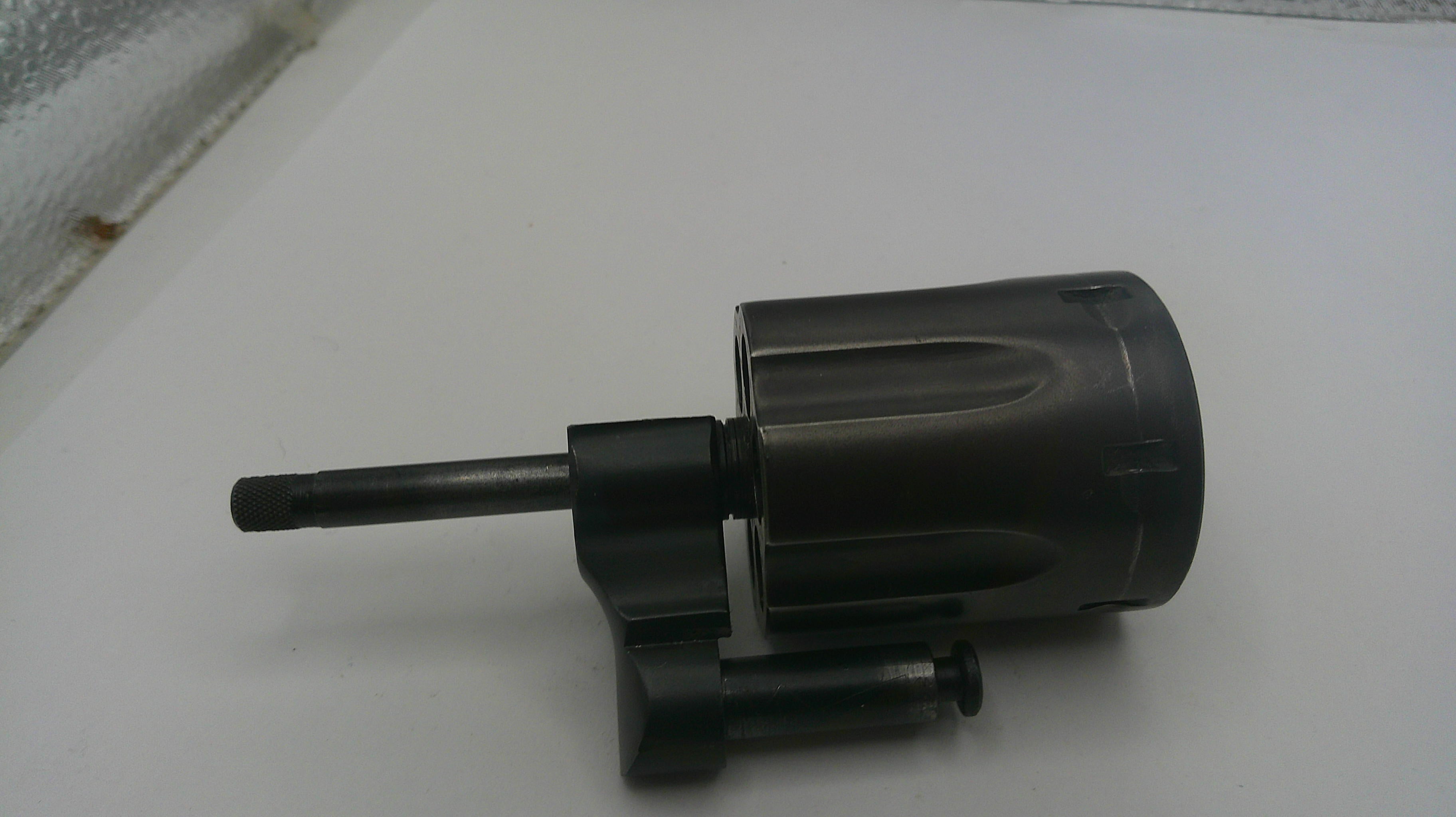 Black cylindrical object with a long nozzle on a white surface