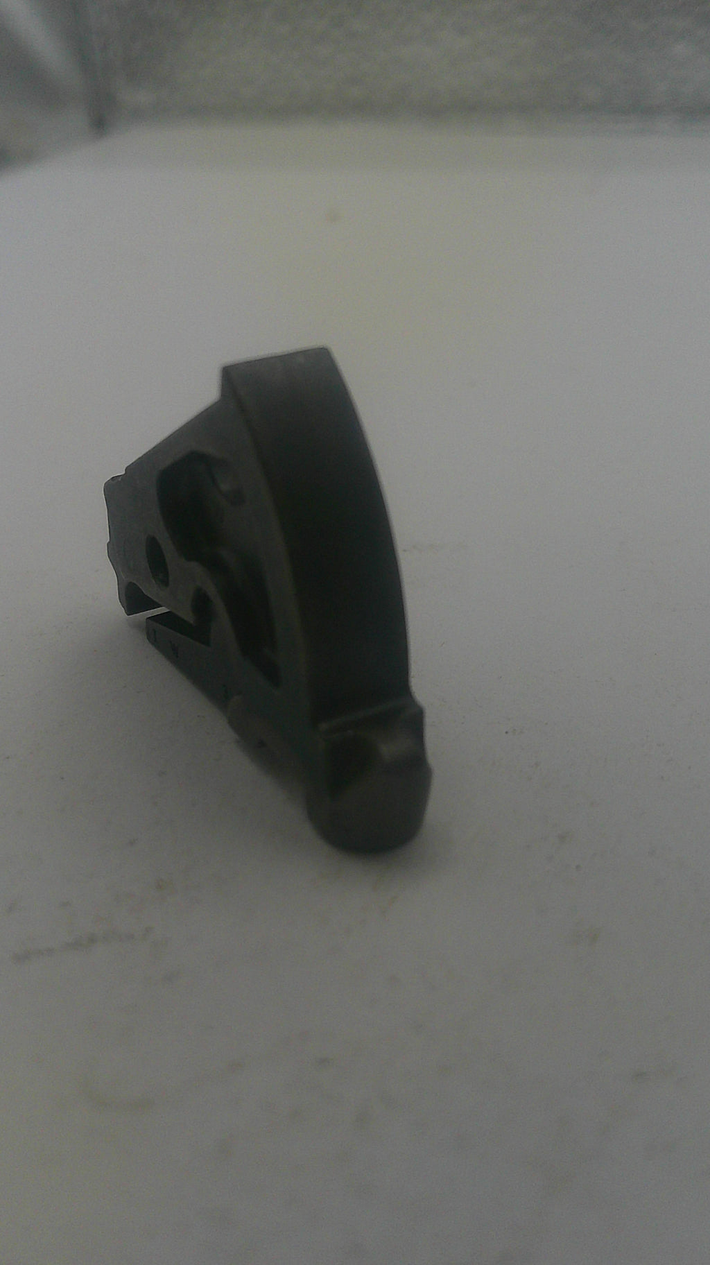 Black plastic component on a white surface