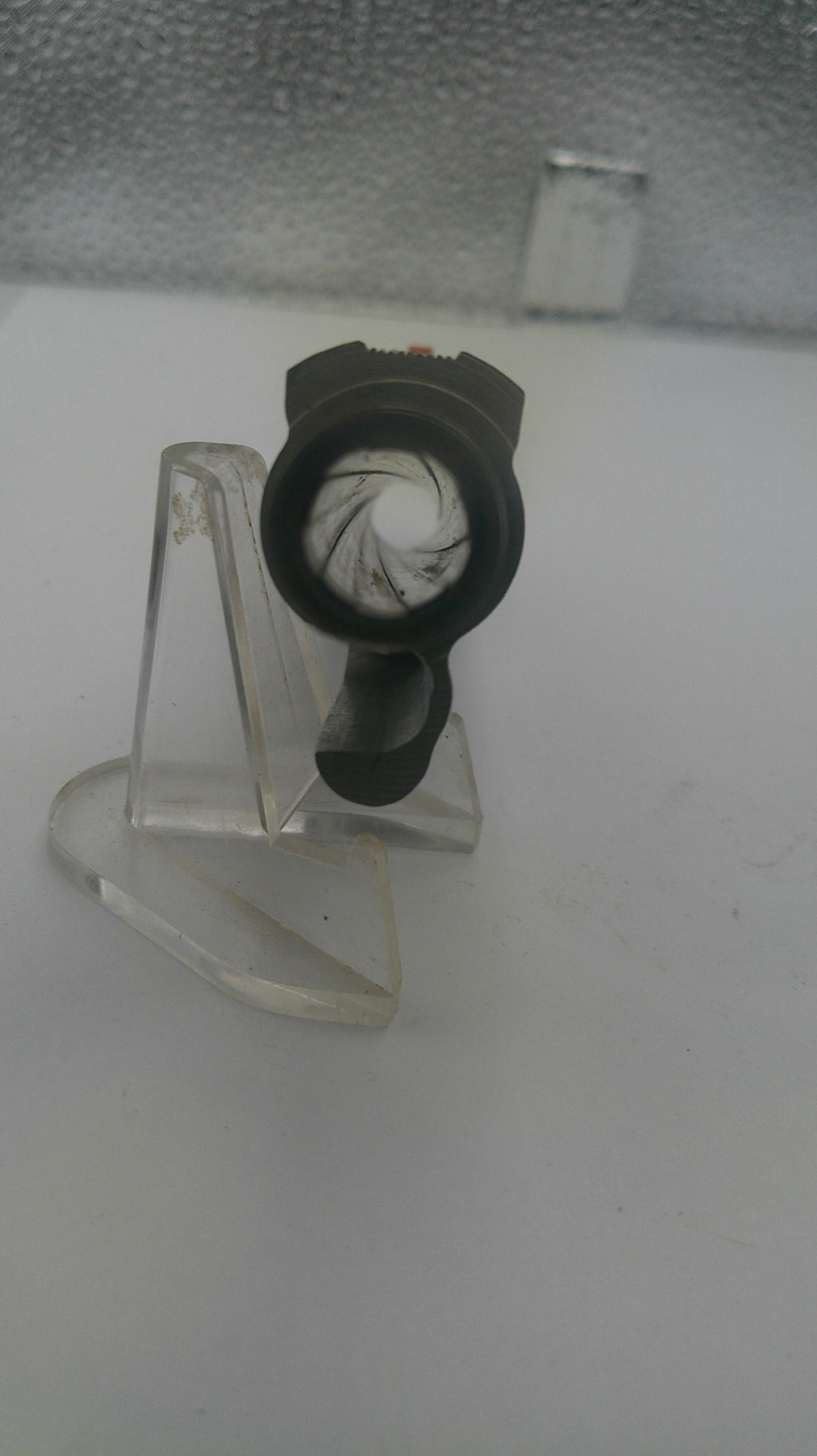 Clear plastic clip with a black component on a white background