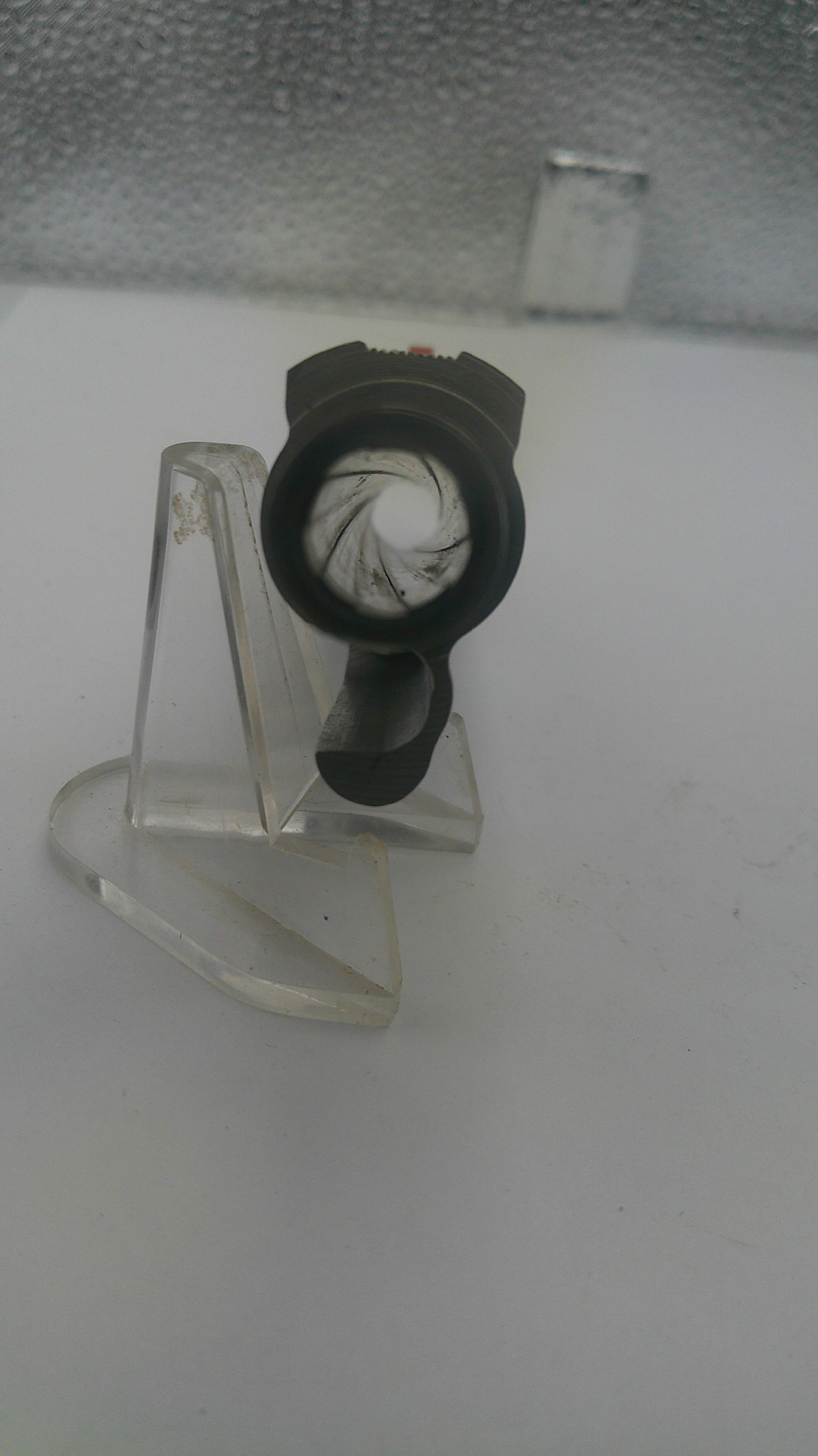 Clear plastic clip with a black component on a white background