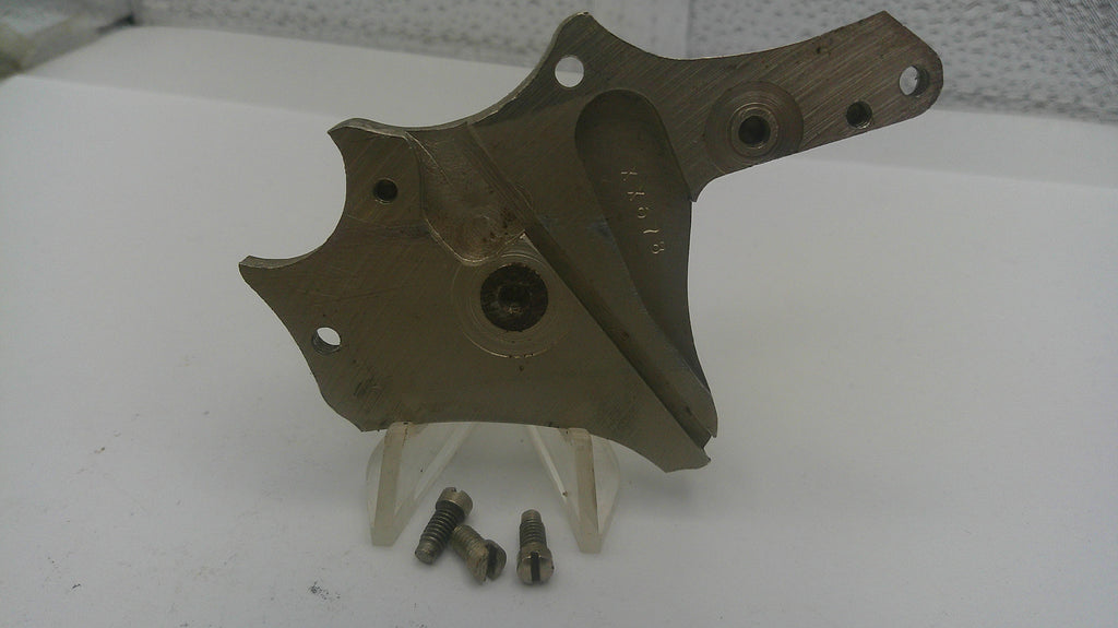 Metal mechanical component on a white surface with small metal parts.