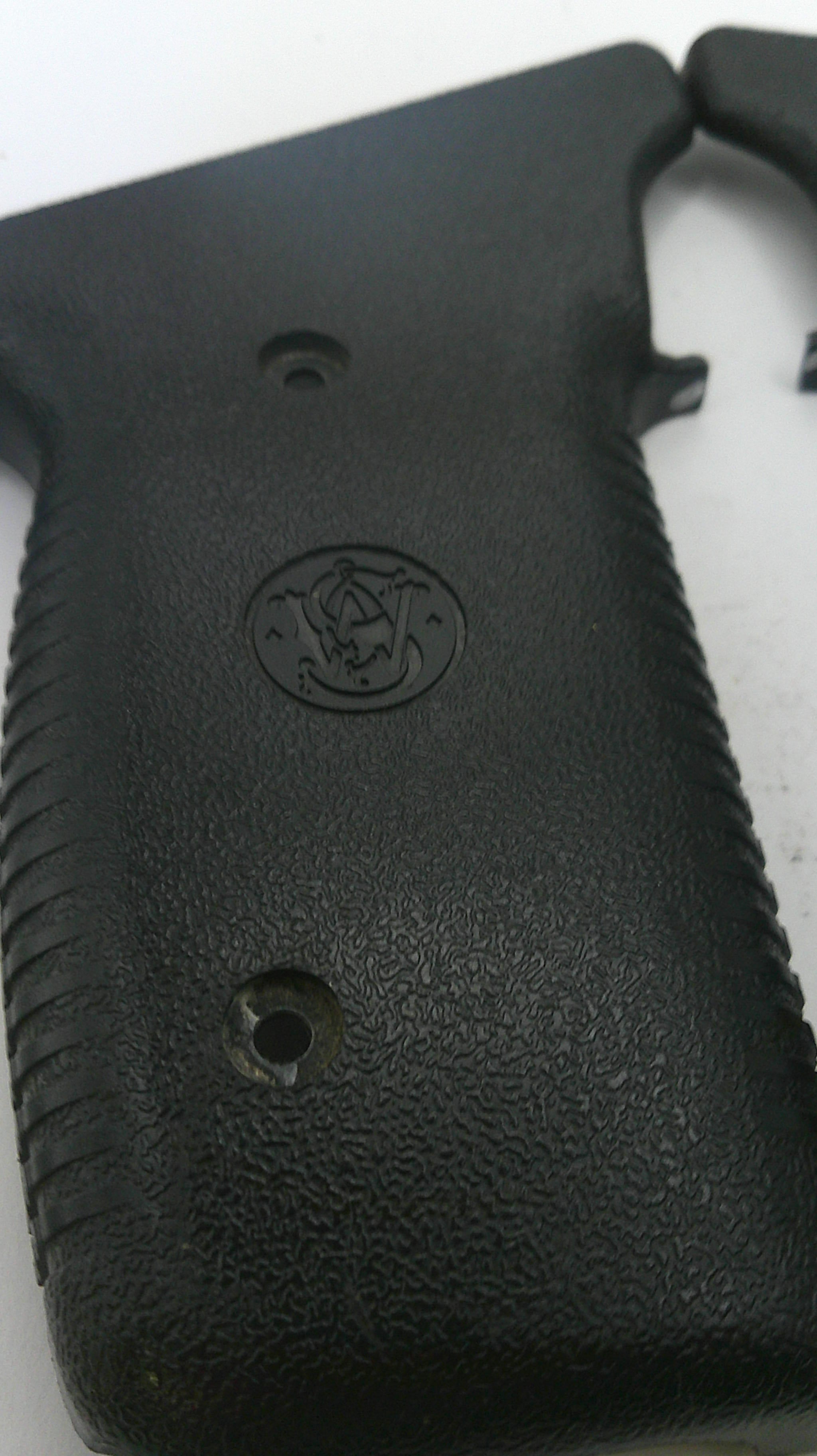 Close-up of a black gun grip with a logo on a white background
