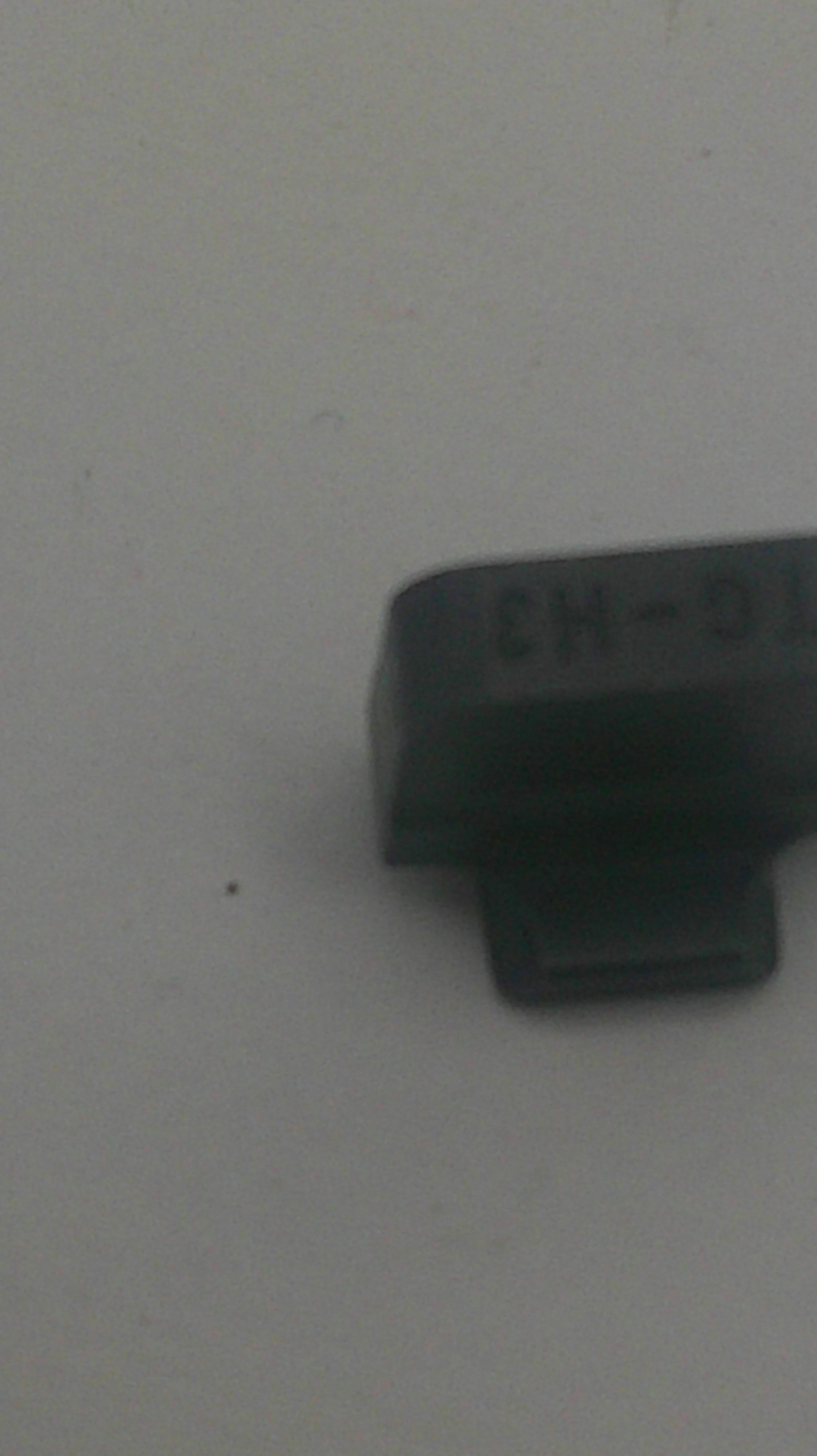 A small black plastic automotive relay component with molded text 'L6-H3' on its side, photographed against a plain light gray background.