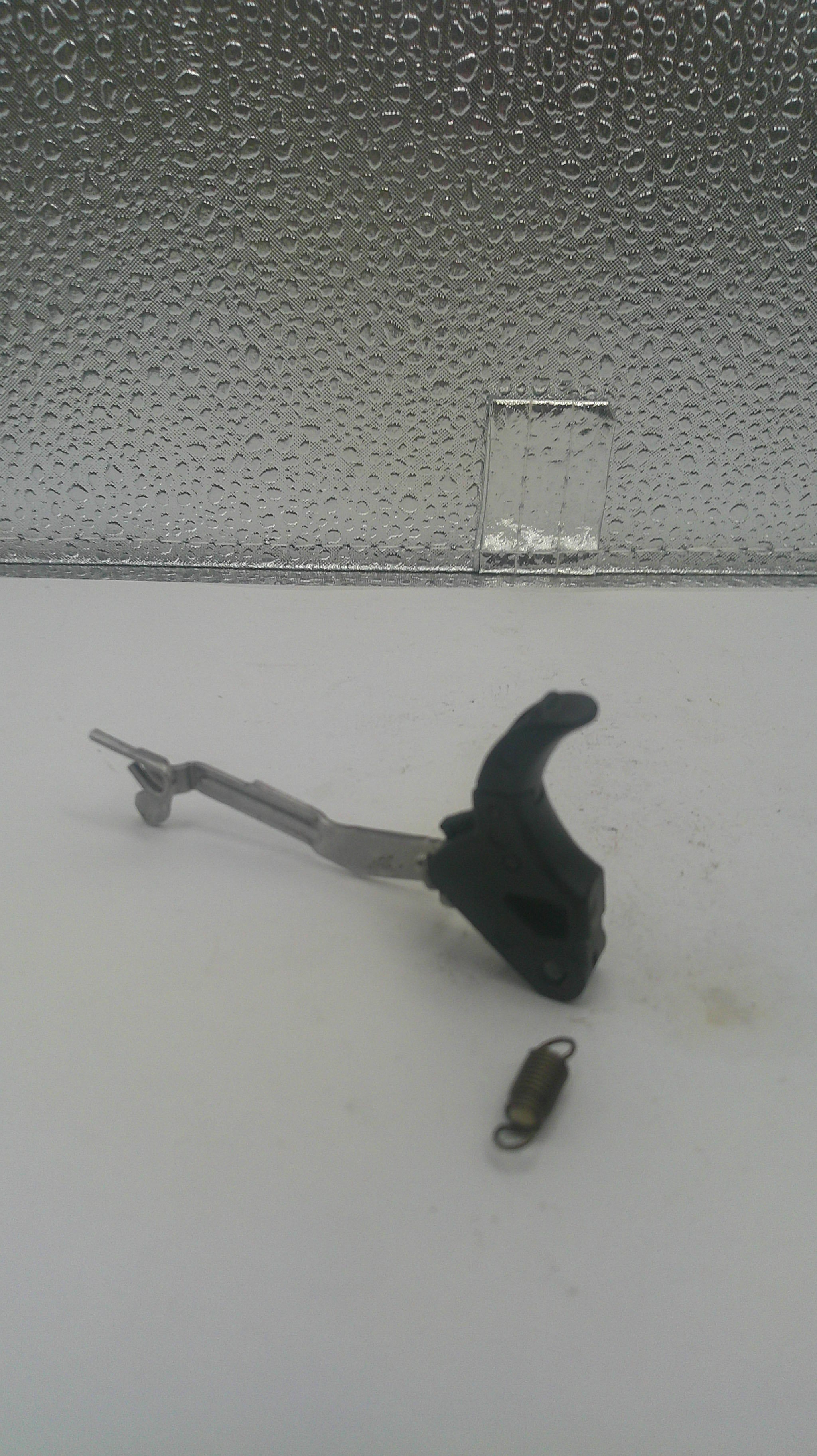 A fishing lure weight and black hook with a metal leader, shown against a split white and textured gray background.