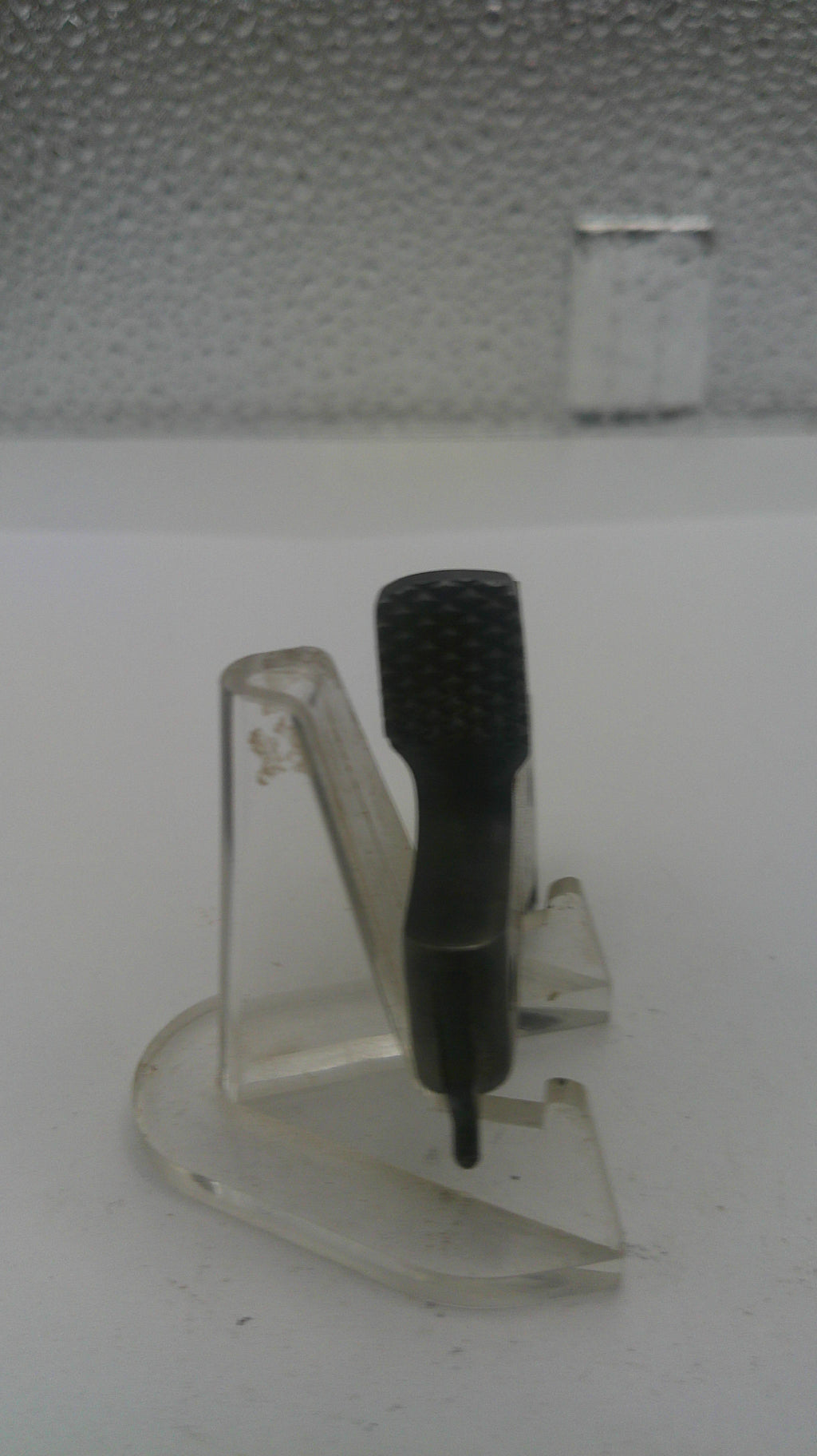 Wall-mounted device with a black probe on a textured white wall