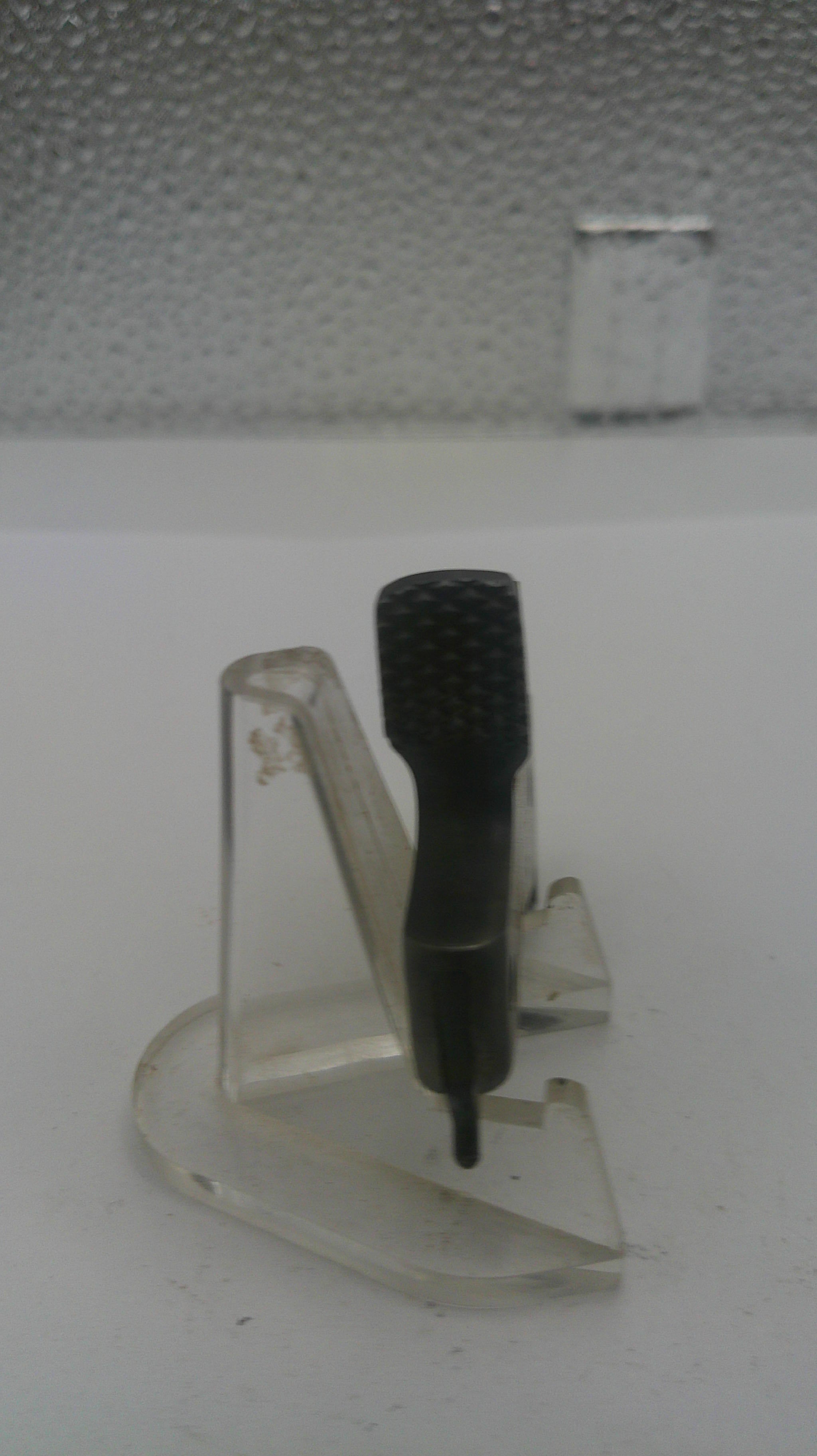 Wall-mounted device with a black probe on a textured white wall