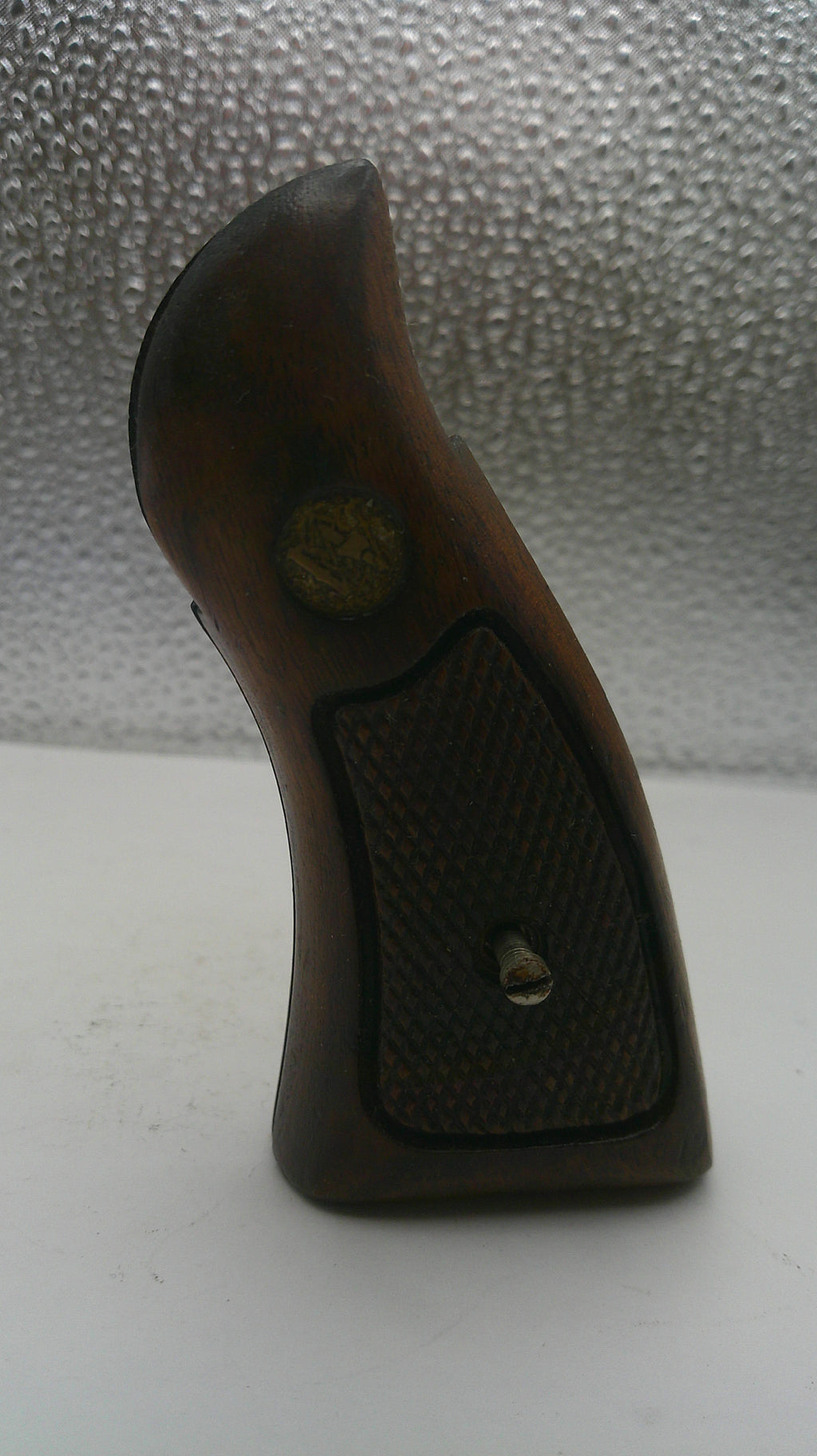 Wooden handle with a textured grip on a white and gray background