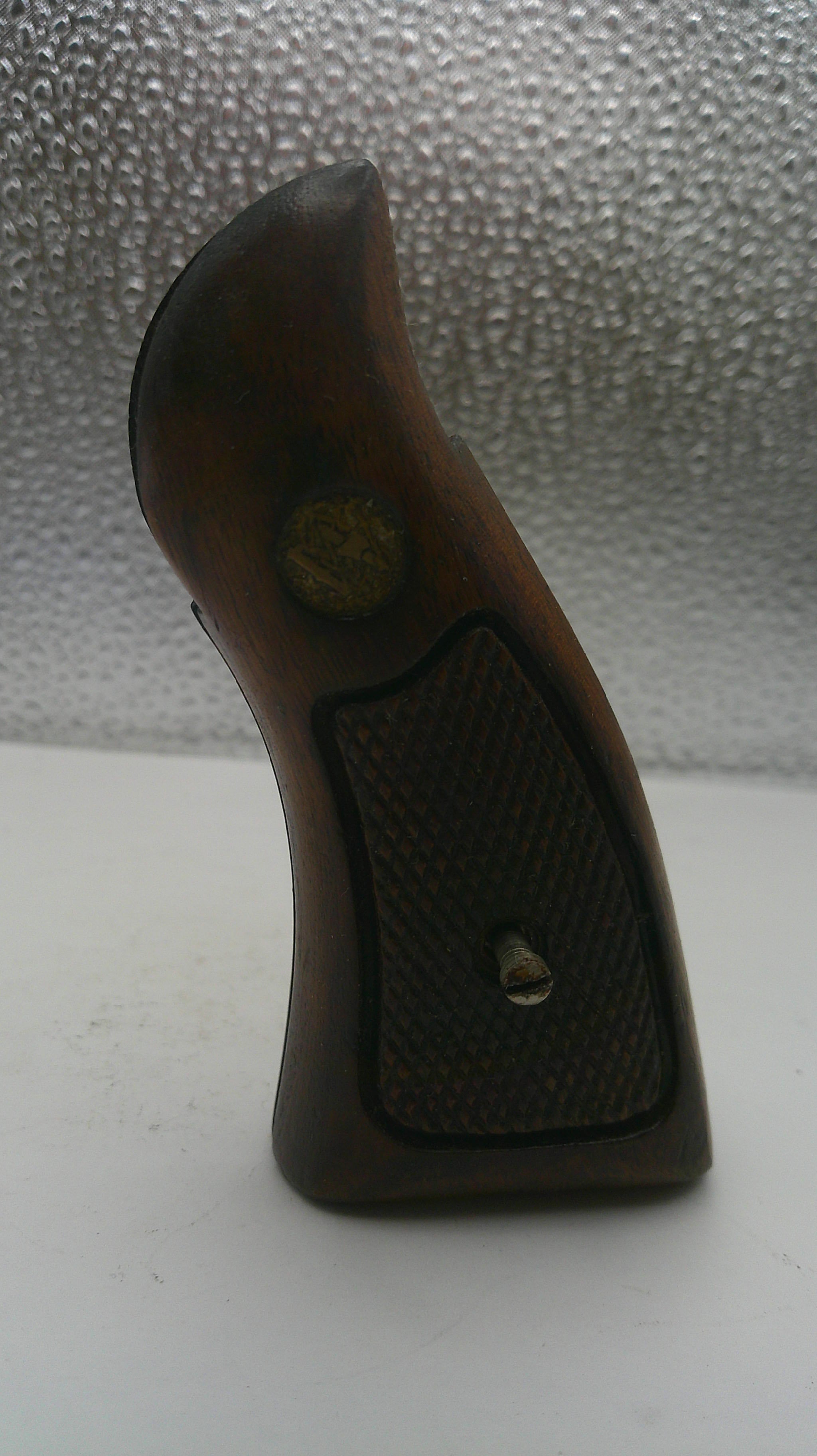 Wooden handle with a textured grip on a white and gray background