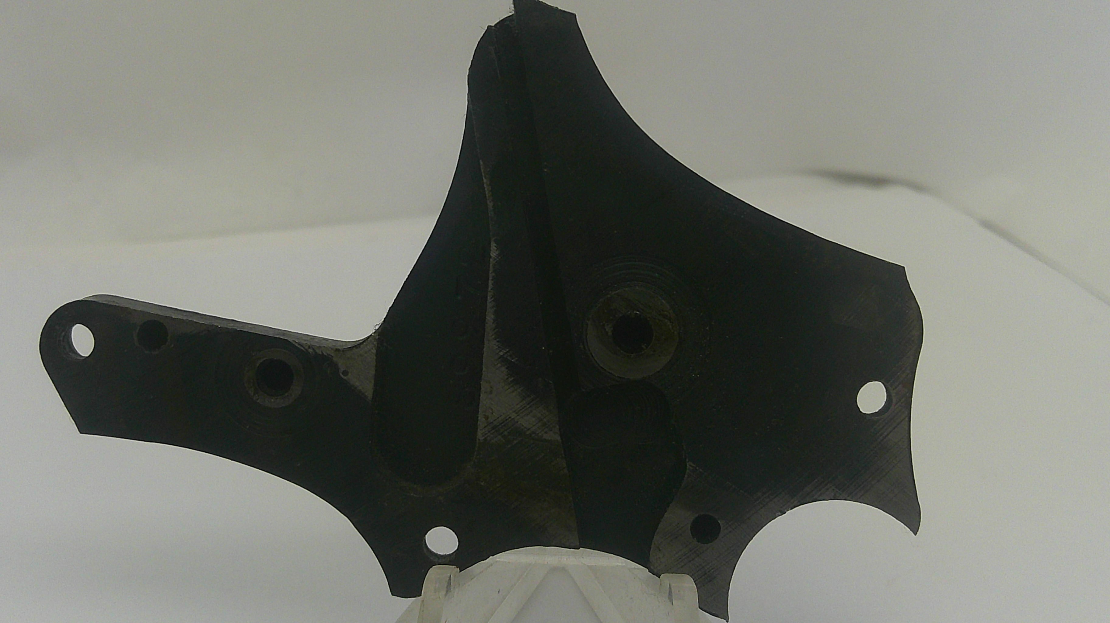 A black metal mounting bracket or hardware piece with pre-drilled holes, shown against a plain white background.
