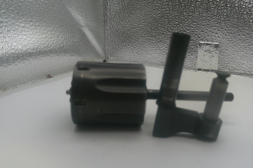 Black mechanical component on a white surface with a textured gray background