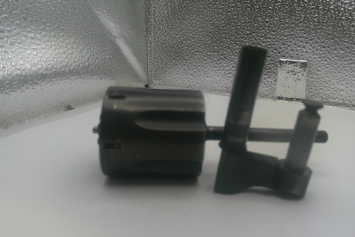 Black mechanical component on a white surface with a textured gray background