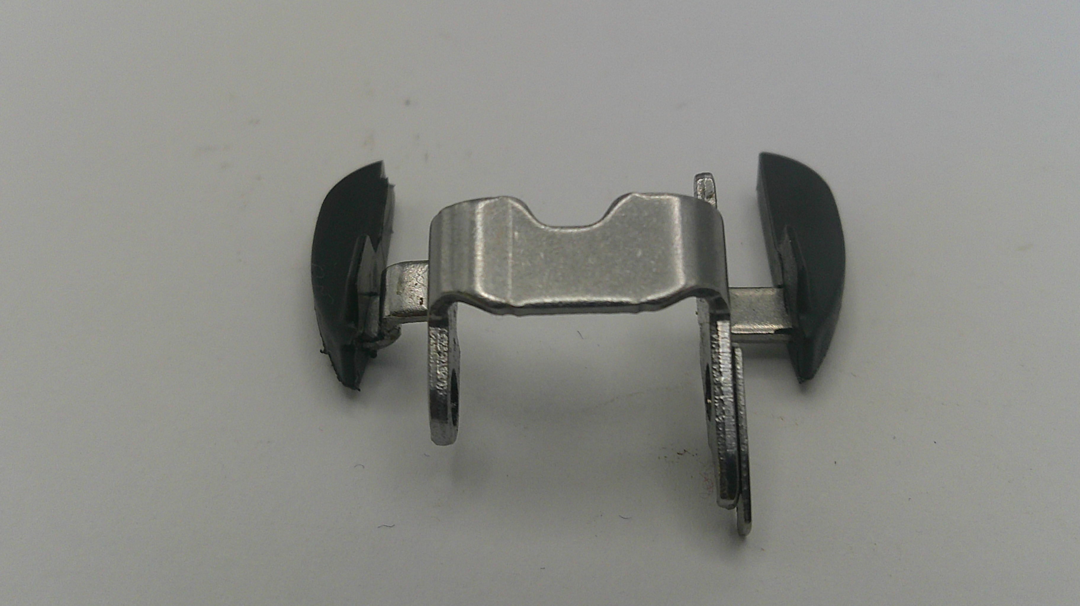 Metallic clip with black ends on a gray background