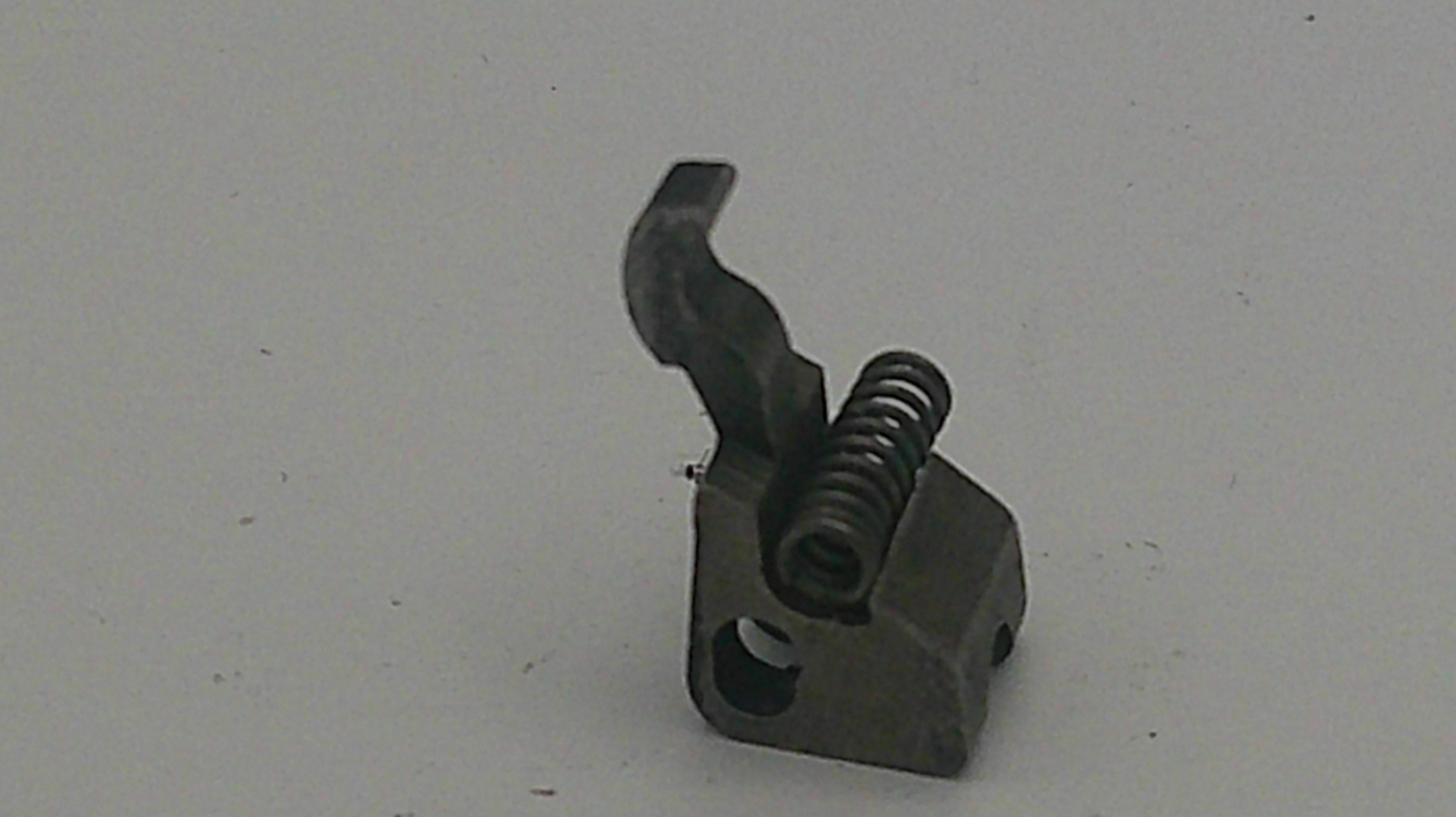 Metal component with a spring on a light gray background