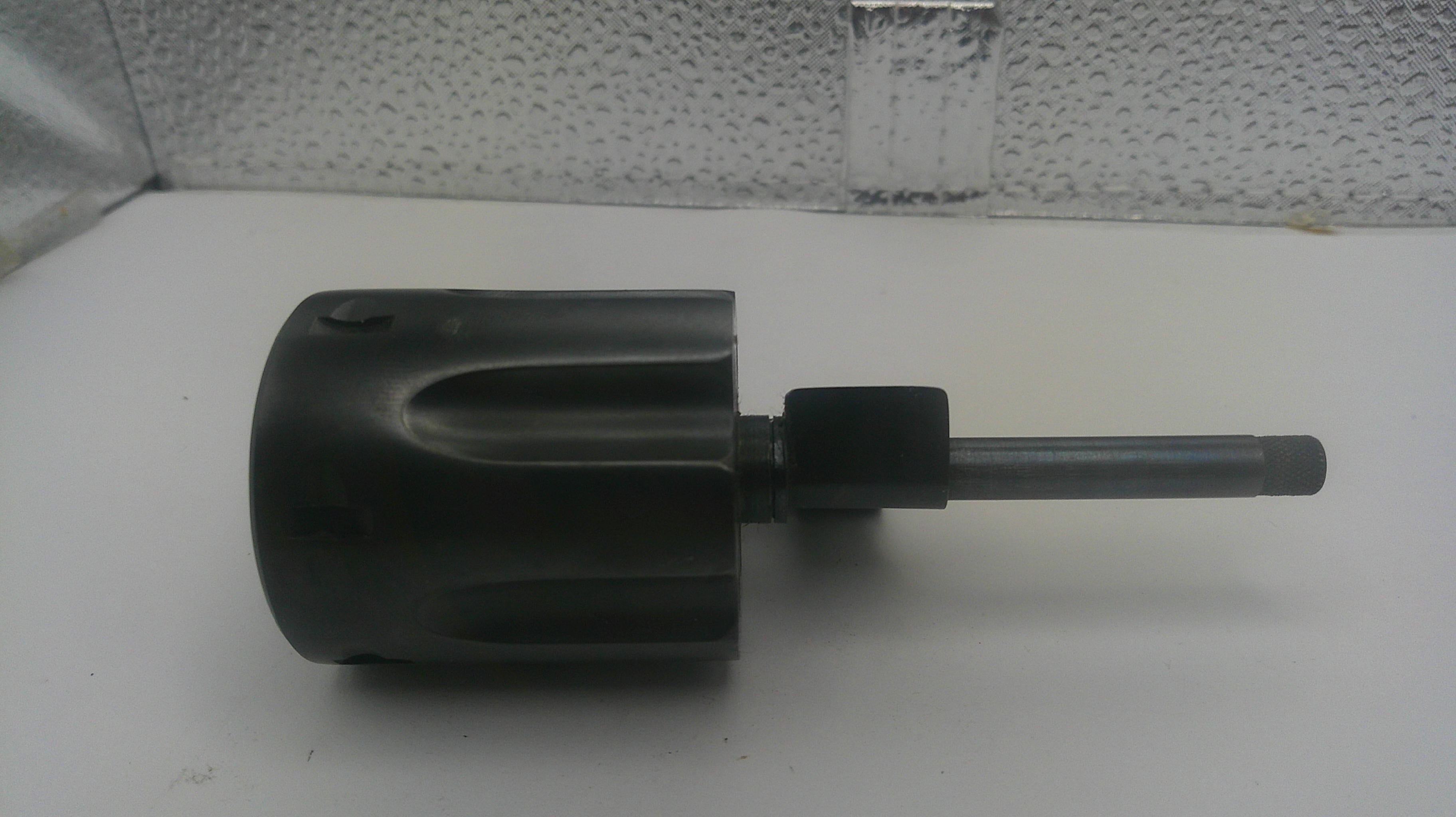 A used black plastic rotary hammer chuck with a metal shank, shown on a white surface with a textured background.