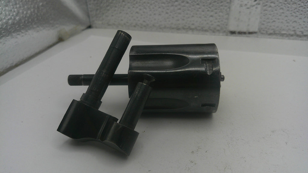Metal tool components on a white surface with a textured wall background