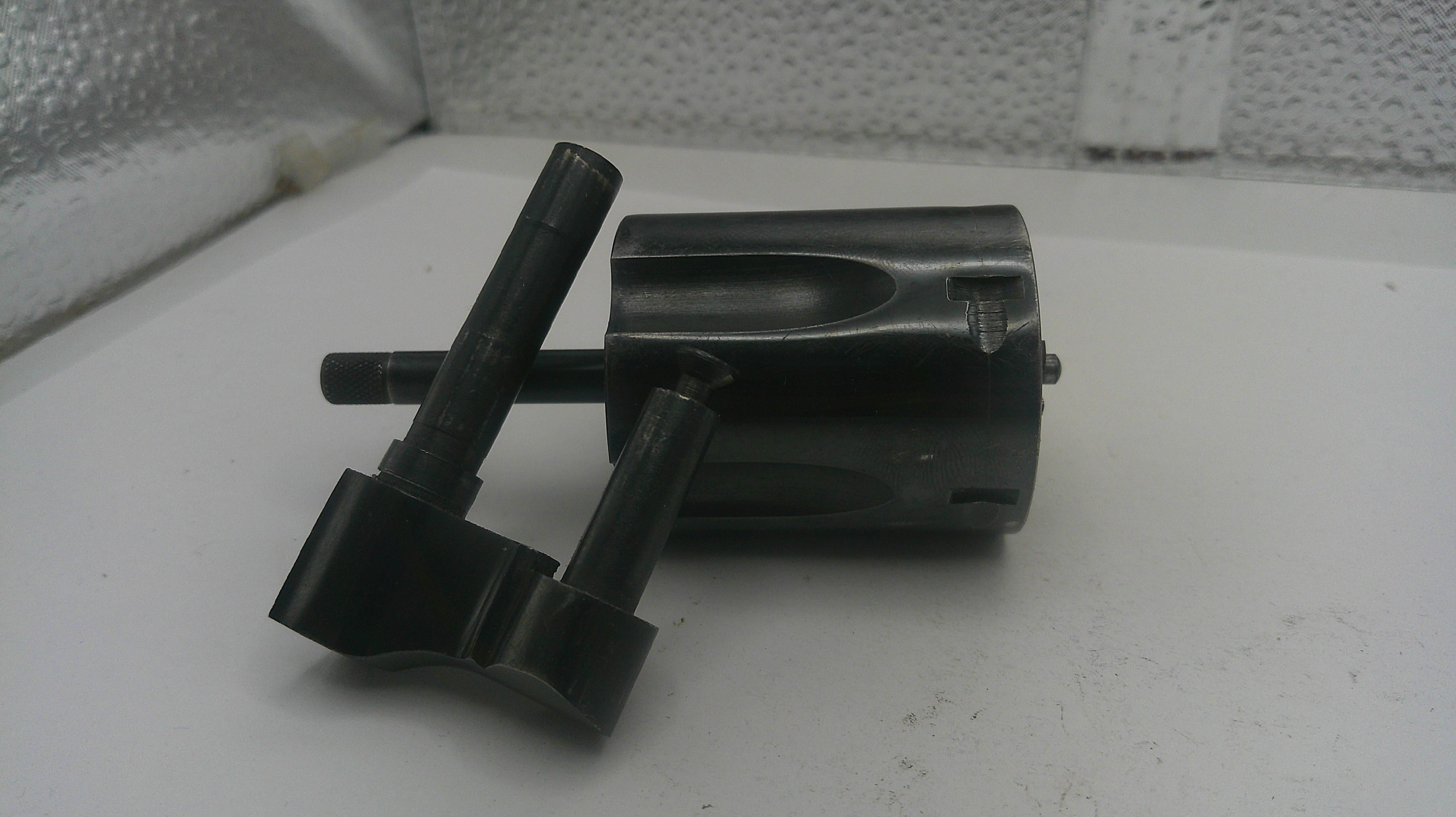 Metal tool components on a white surface with a textured wall background