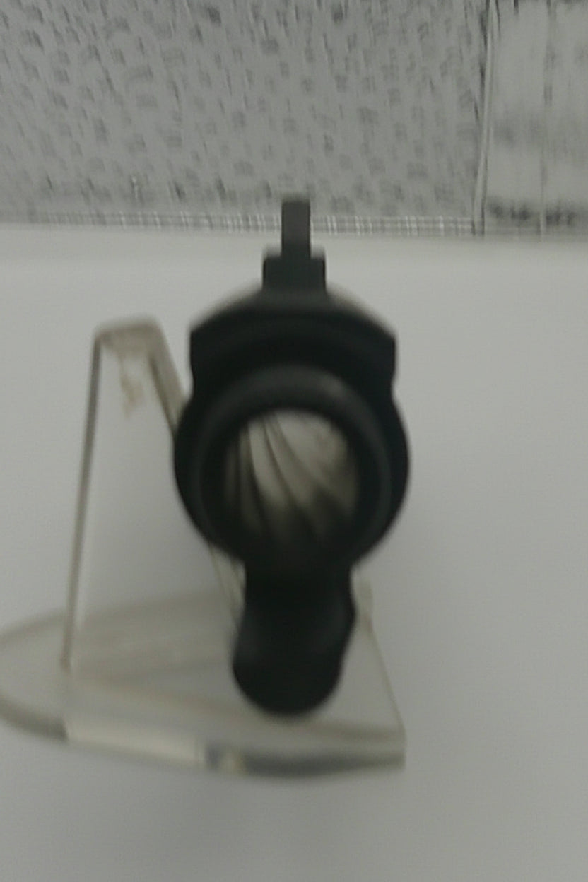 Clear plastic component on a white surface with a patterned background