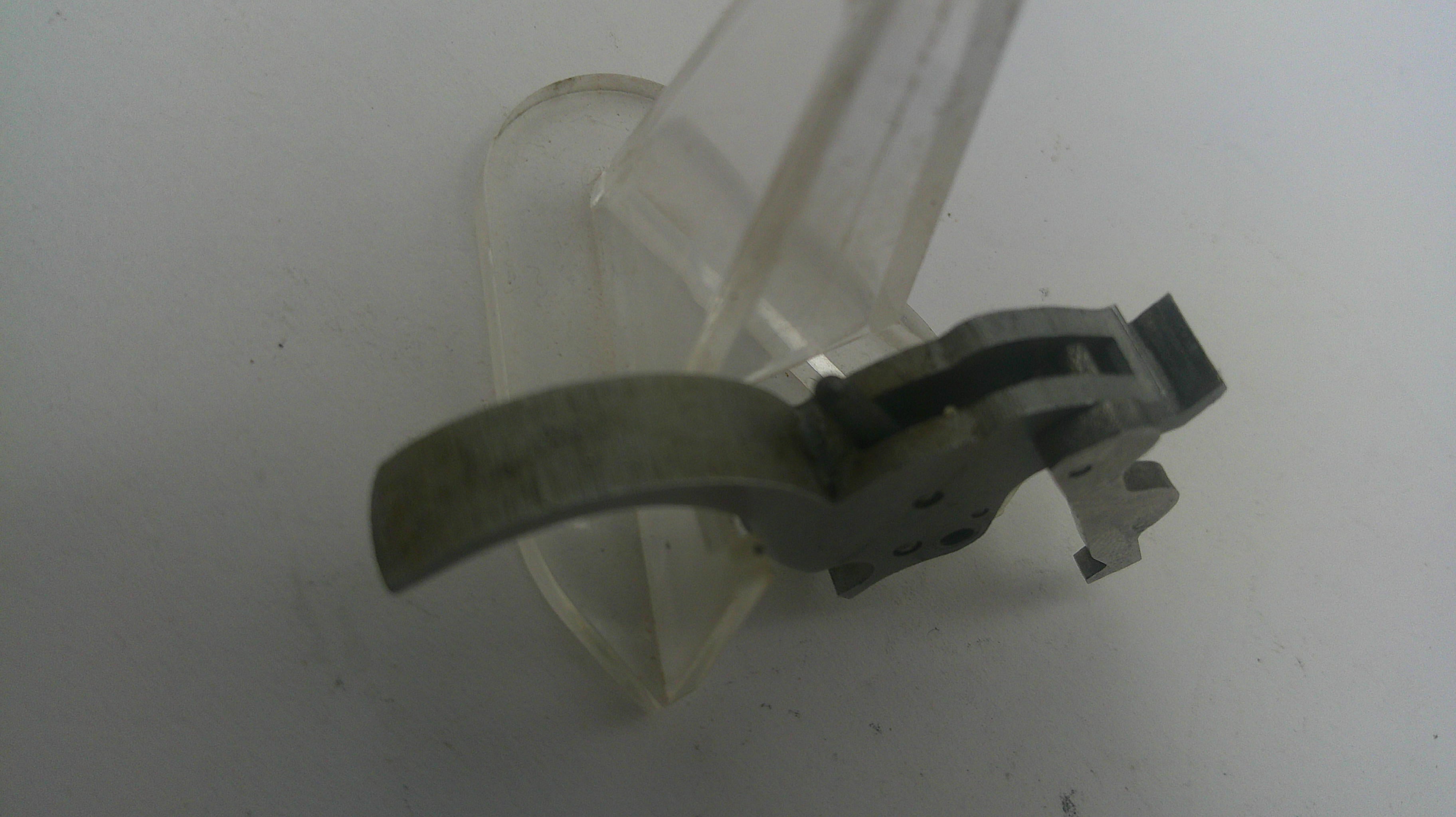 Clear plastic component with metal parts on a white background