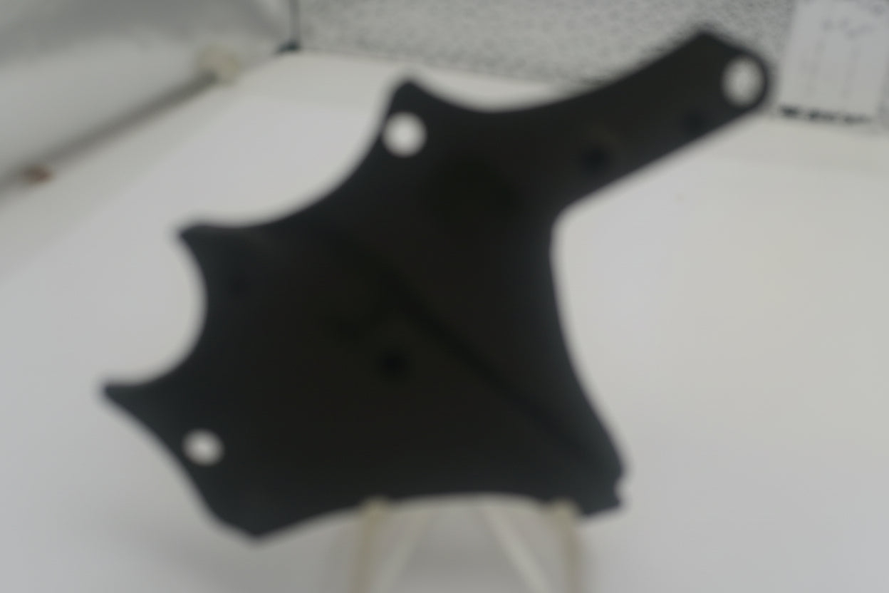 Black guitar pickguard on a white surface
