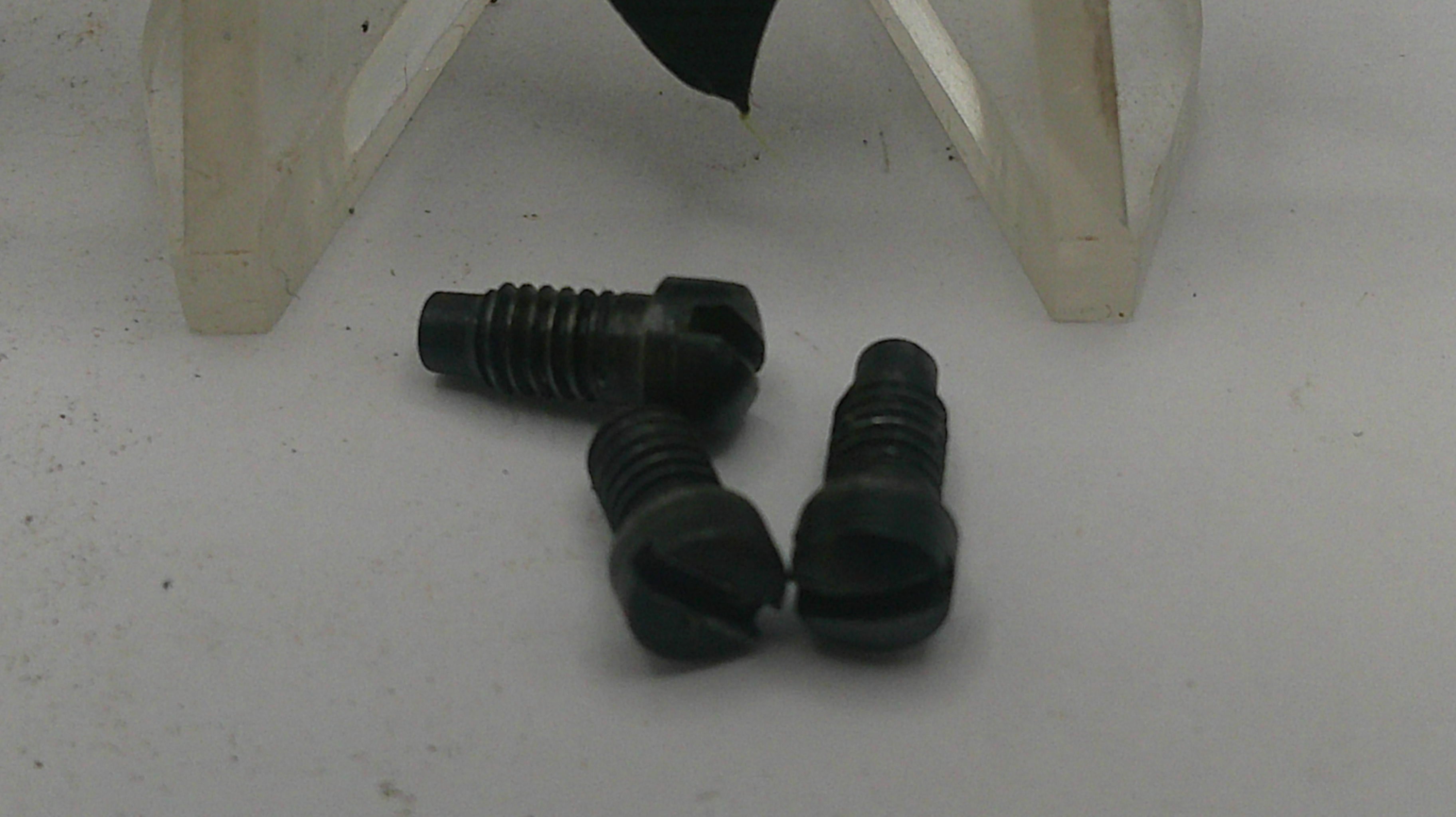 Three black screws on a white surface