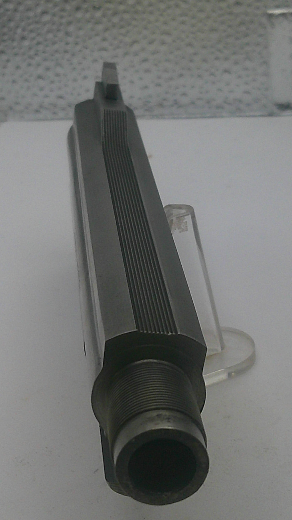 Black cylindrical object on a stand against a white background
