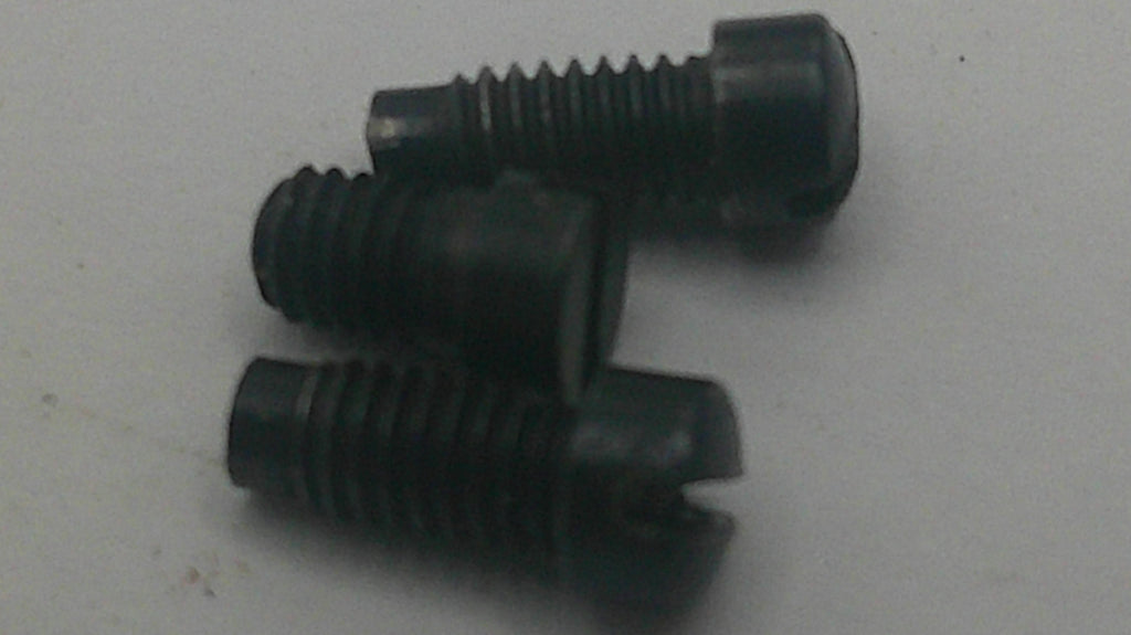 Three black slotted flat head screws on a light gray background.