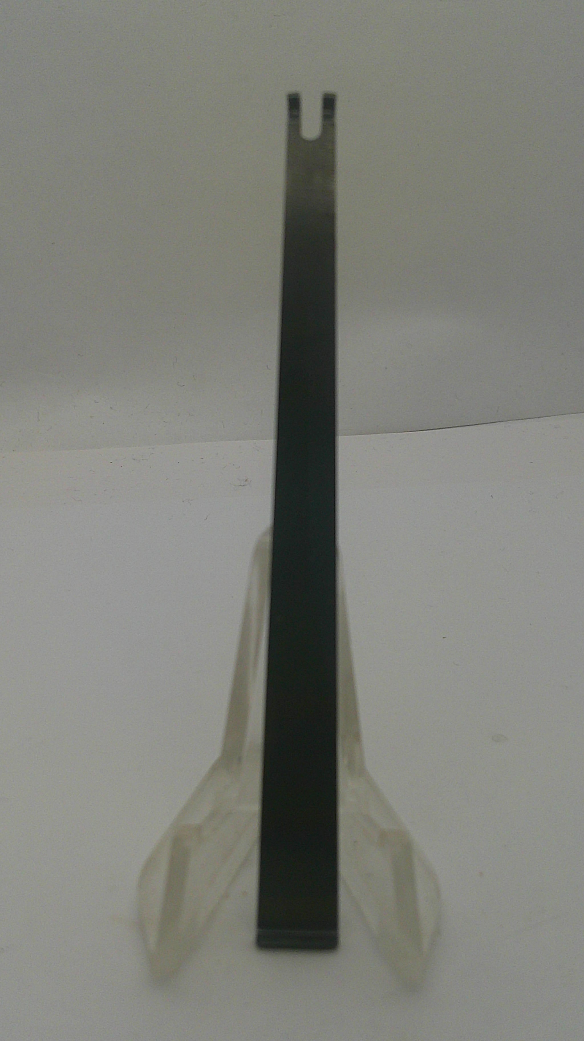 A flat metal pry bar or tool with a black handle and silver-toned tip, resting on a white surface.
