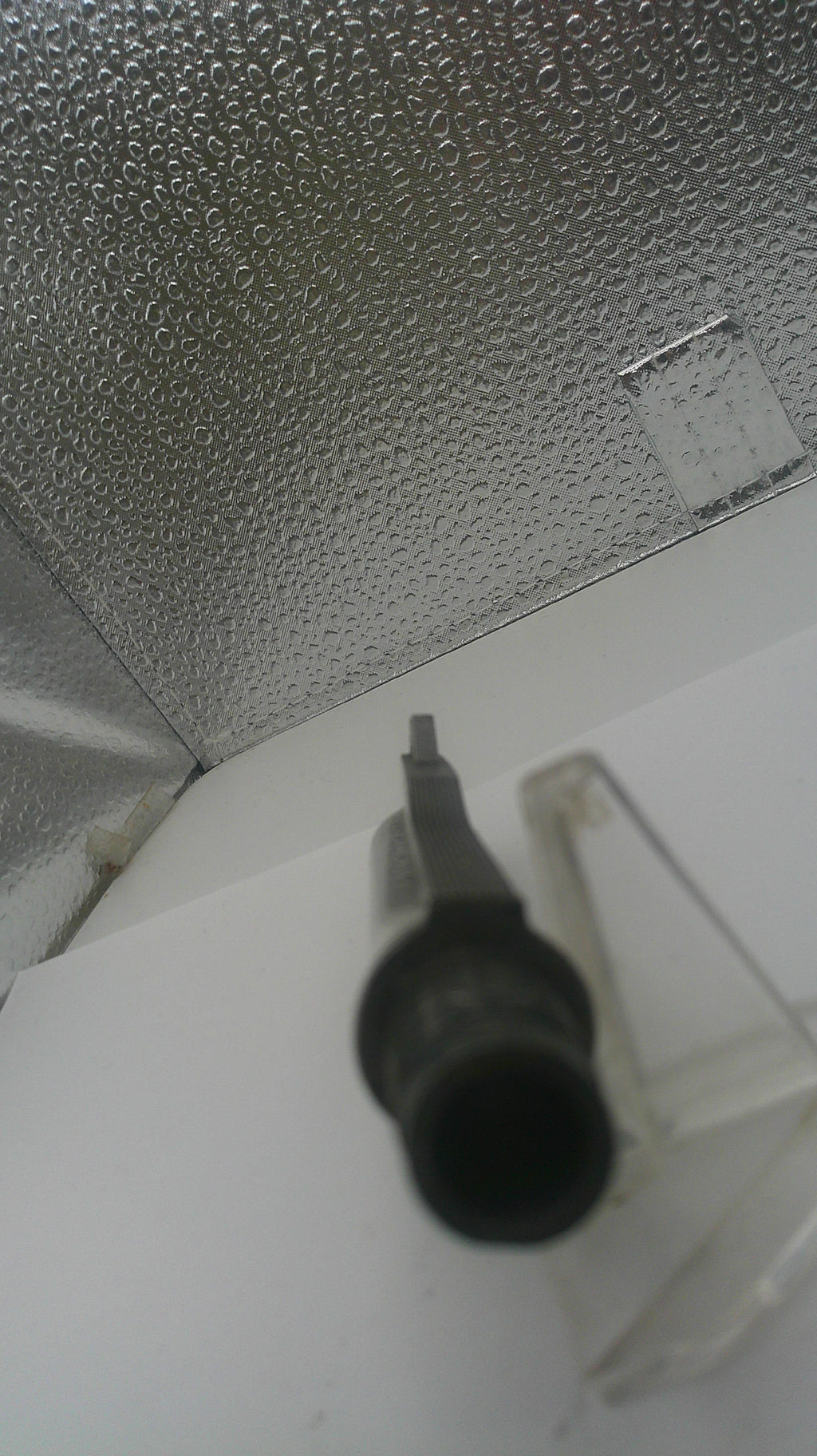 Black screwdriver on a textured metallic surface