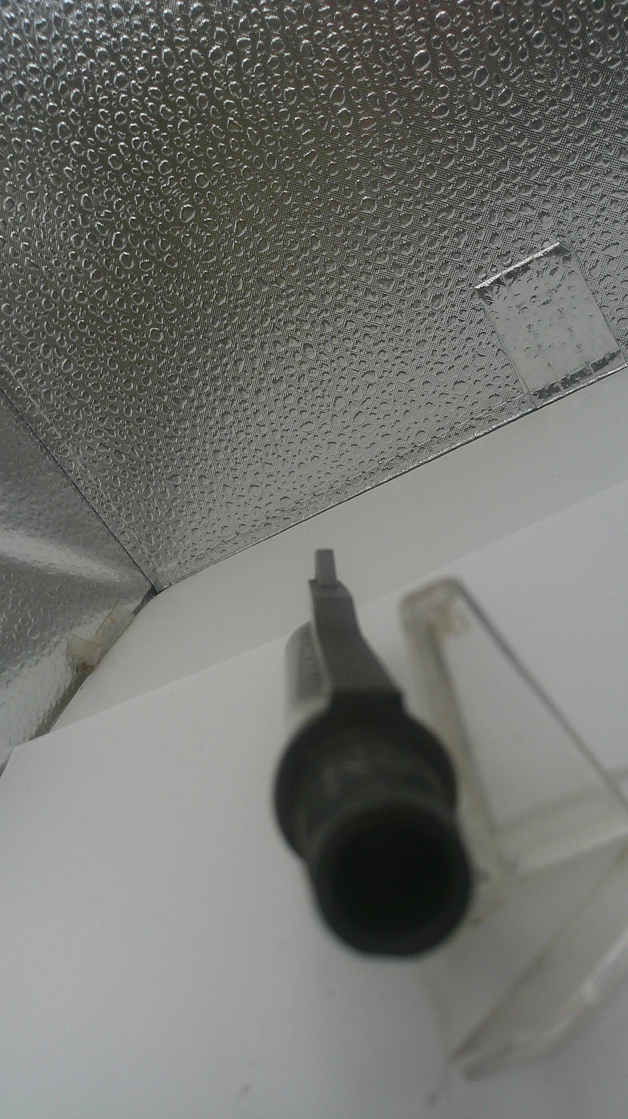 Black screwdriver on a textured metallic surface