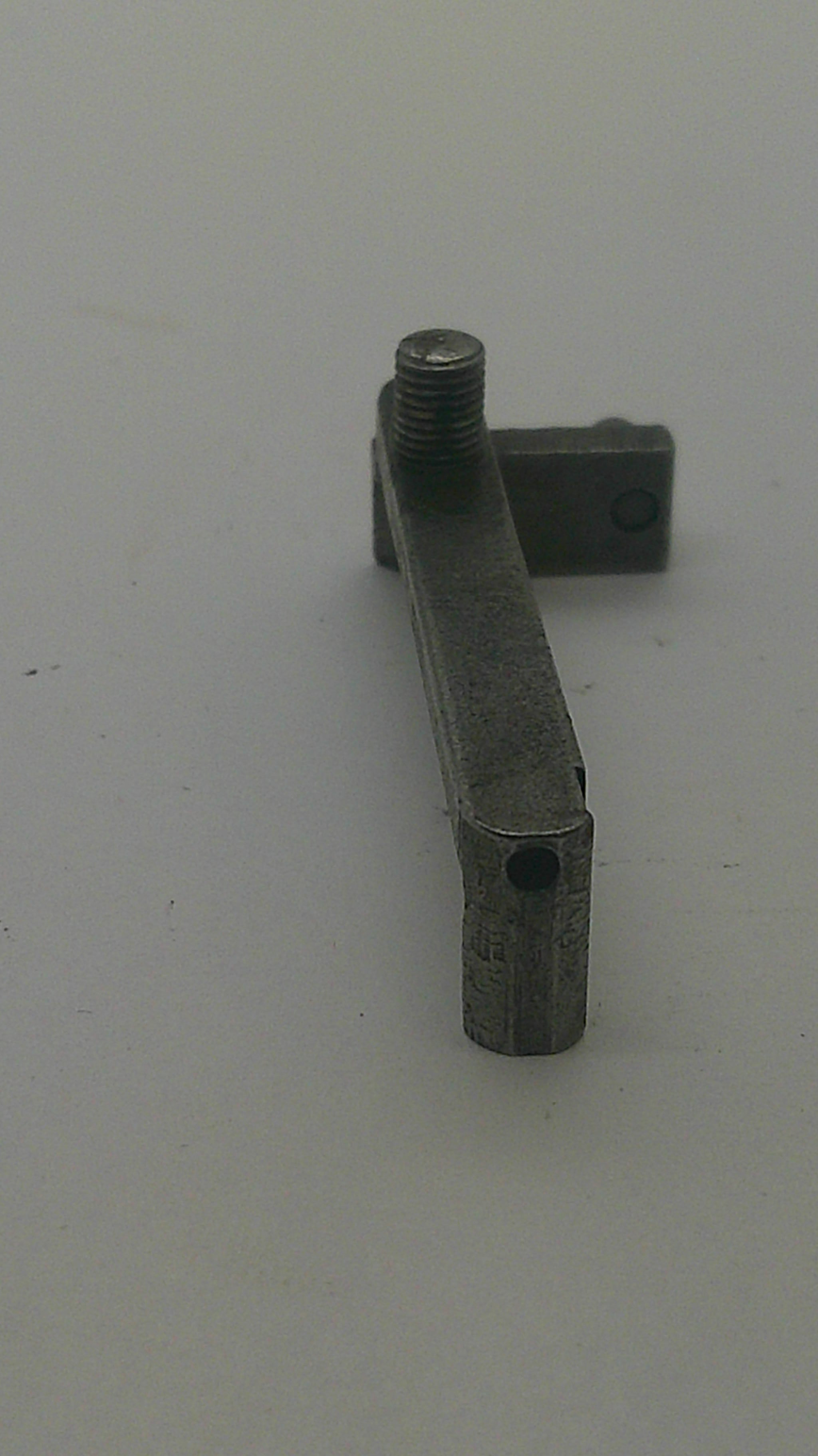 A small metal hardware component with a flat rectangular arm and a threaded bolt extending from the right side, shown against a plain light background.