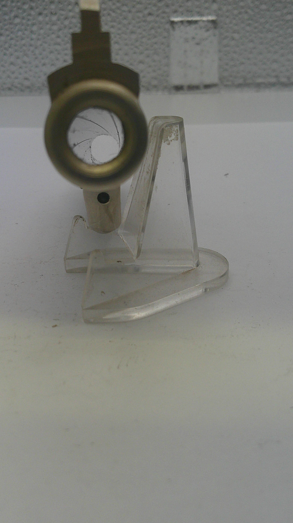Metal valve on a stand against a white wall