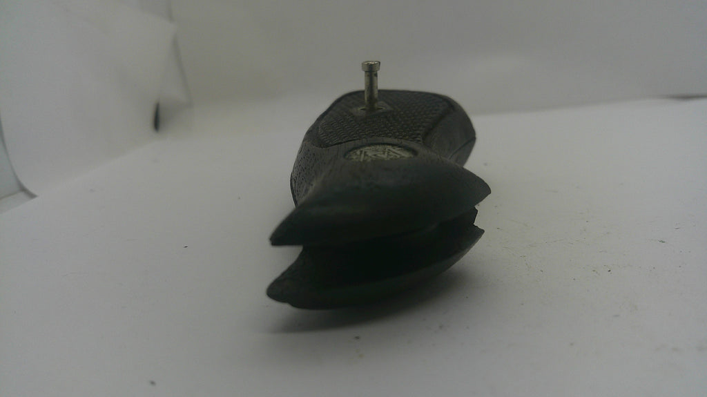 A small black textured pouch or case with a pointed top and a small metal pin protruding from it, photographed on a plain white surface.