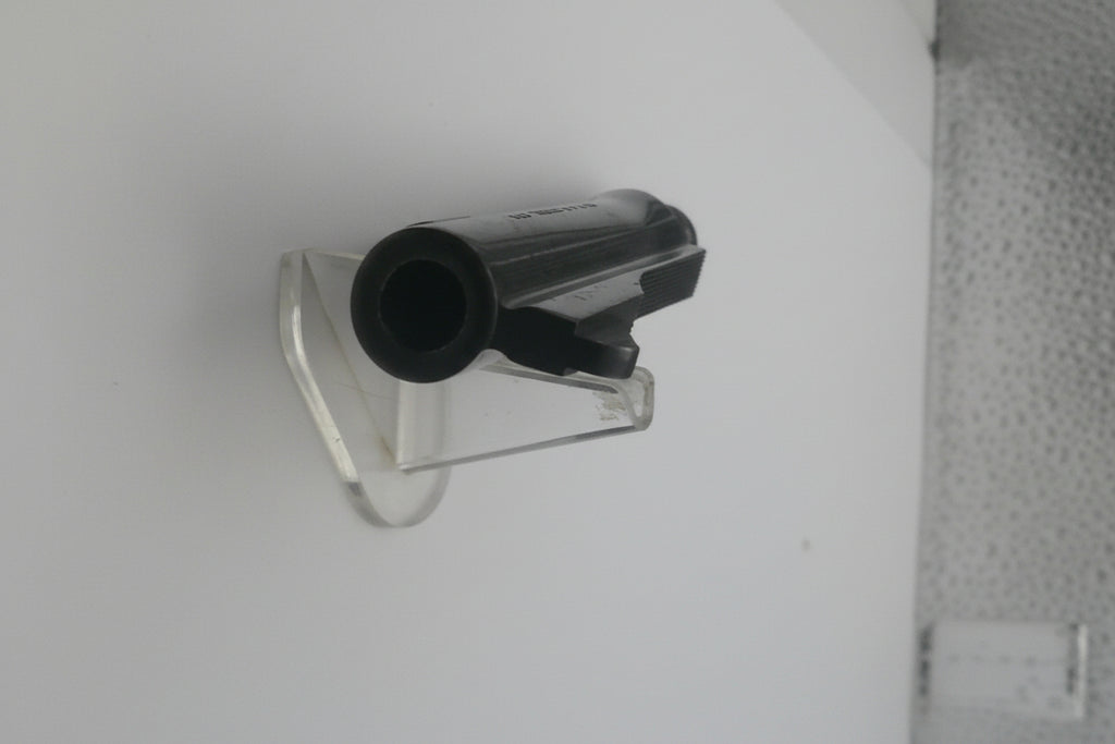 Small black and clear plastic component on a white background