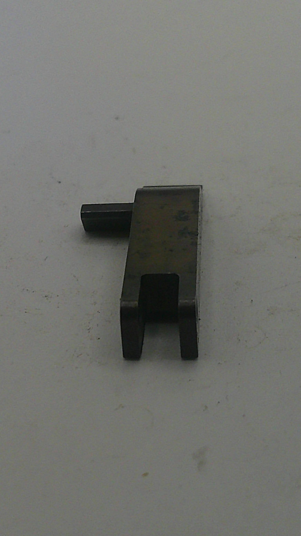 Small metallic object on a light gray background