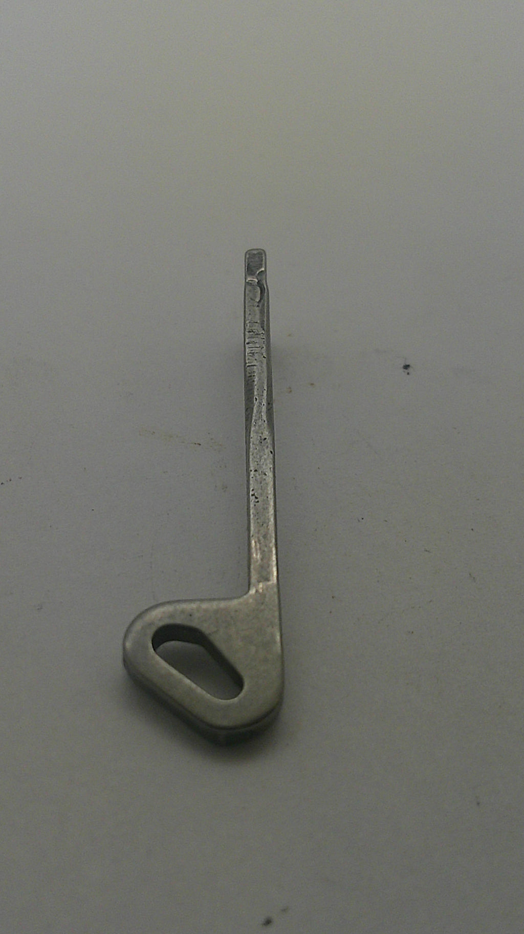 A small silver metal latch or bracket with a looped end, photographed on a plain light gray surface.