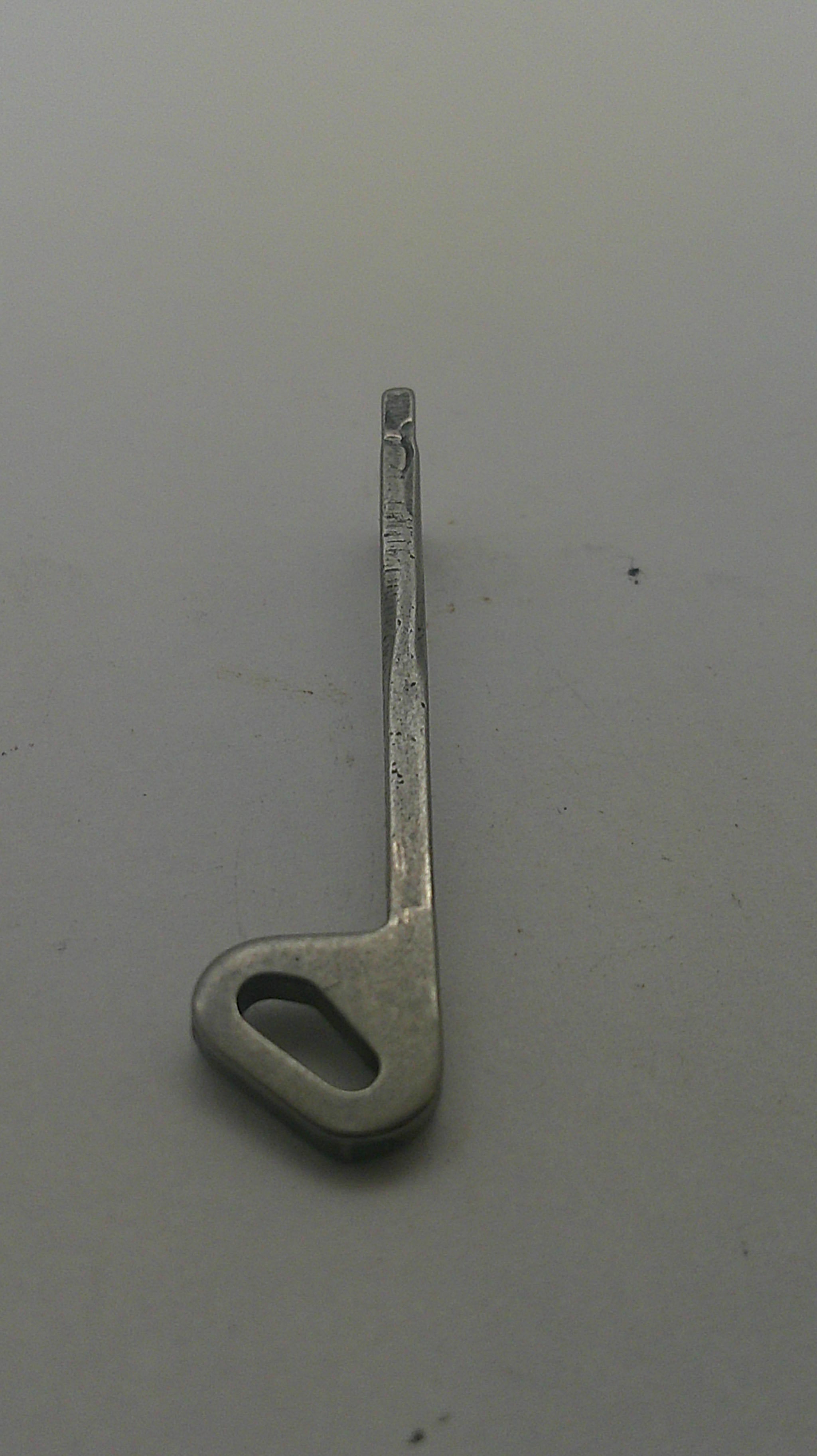 A small silver metal latch or bracket with a looped end, photographed on a plain light gray surface.